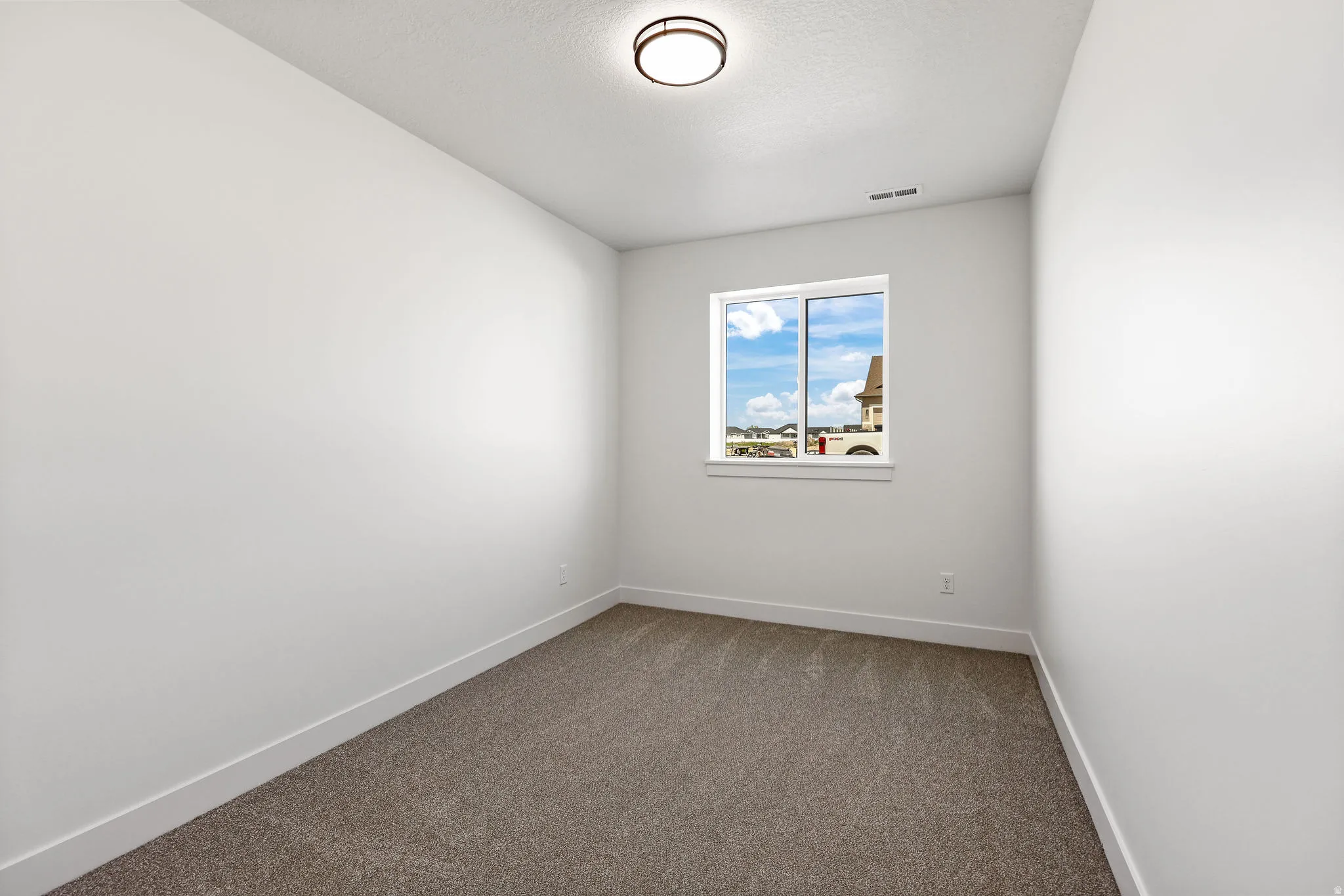 Unfurnished room with dark carpet and a textured ceiling