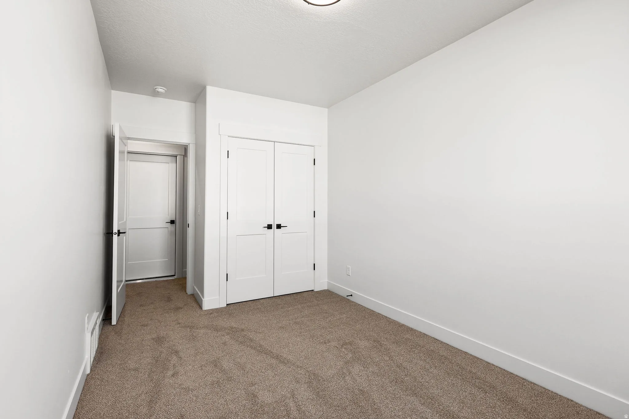 Unfurnished bedroom featuring carpet flooring and a closet