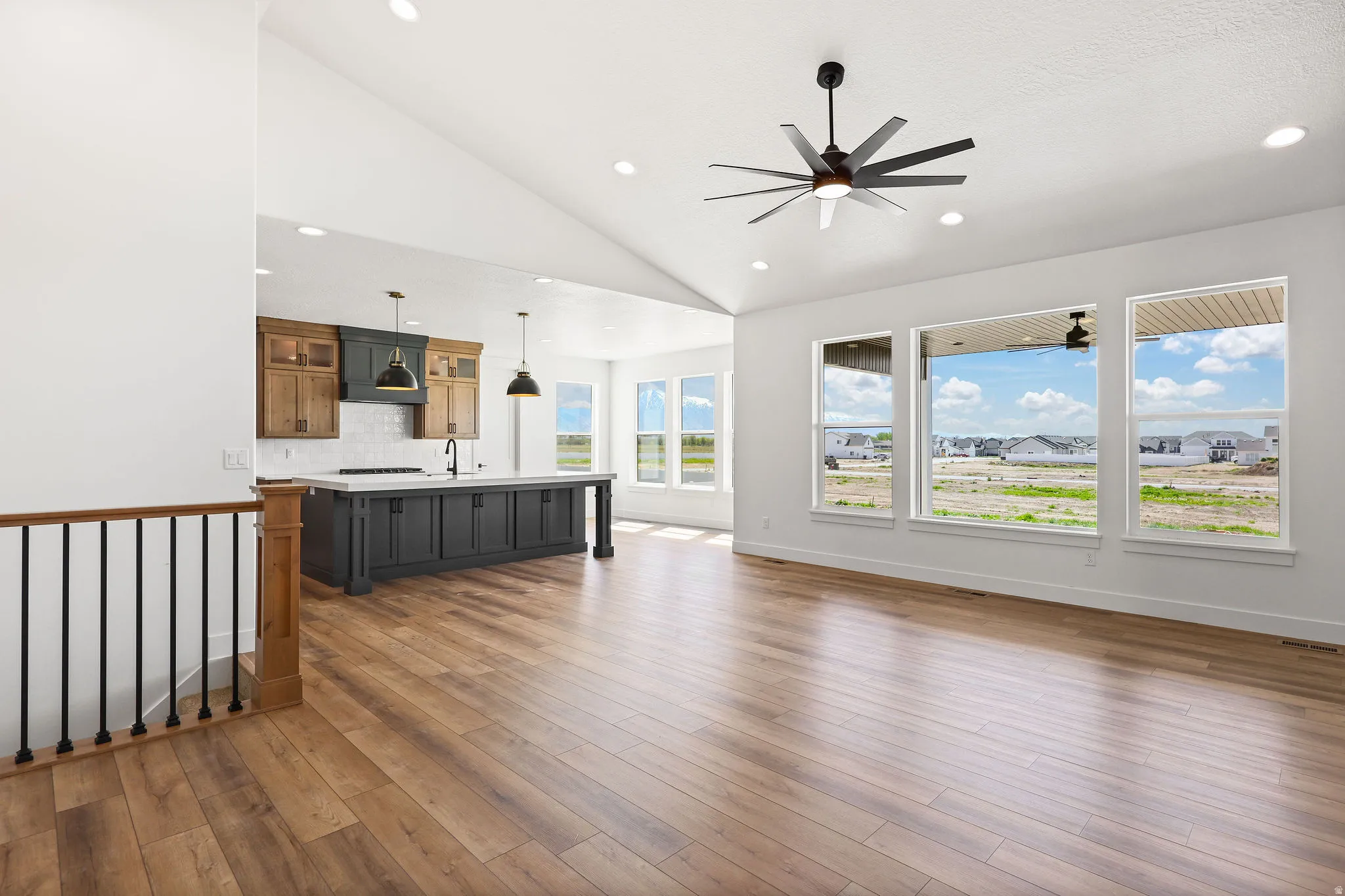 Unfurnished living room with lofted ceiling, dark wood-style flooring, and a ceiling fan