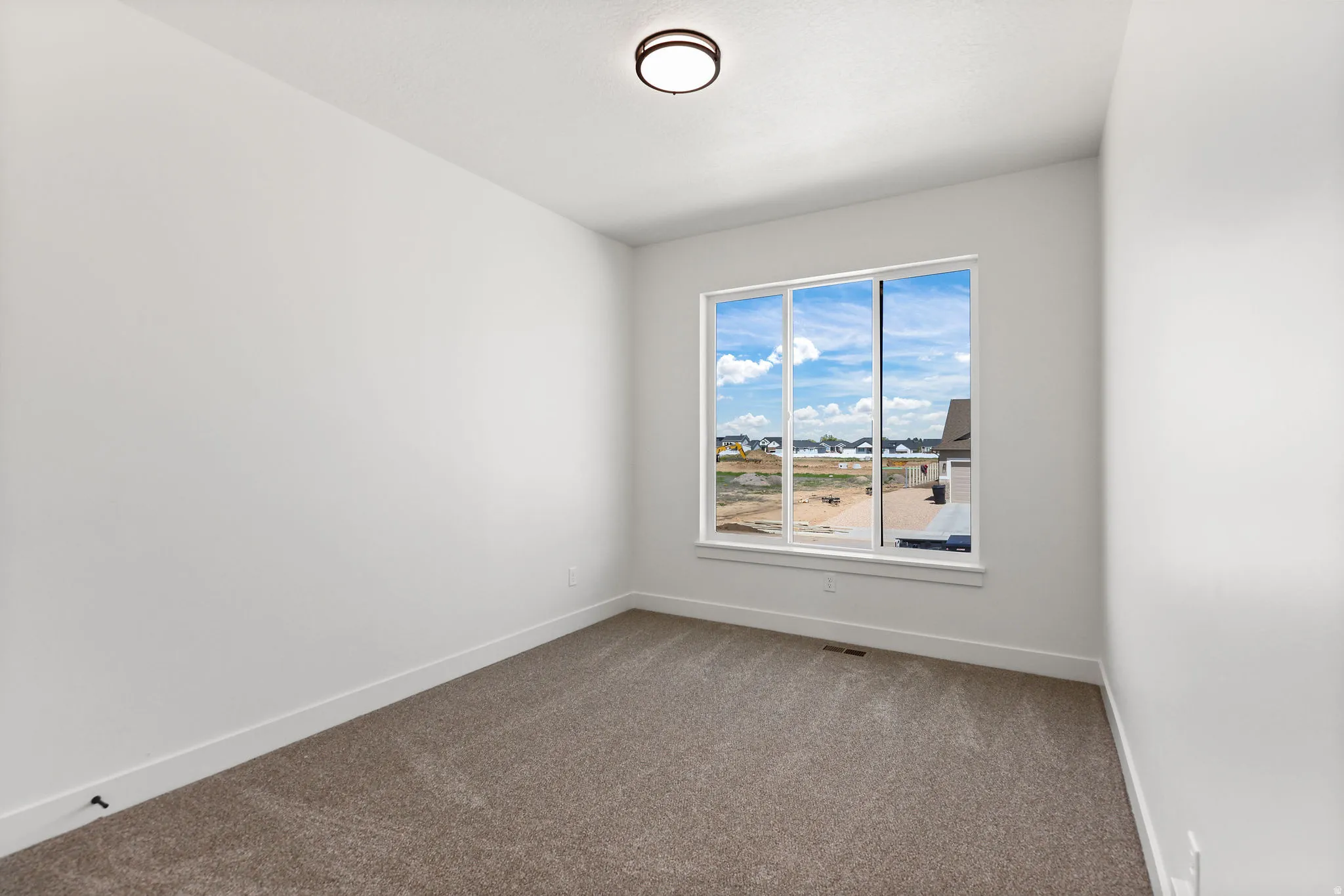 Carpeted spare room with baseboards