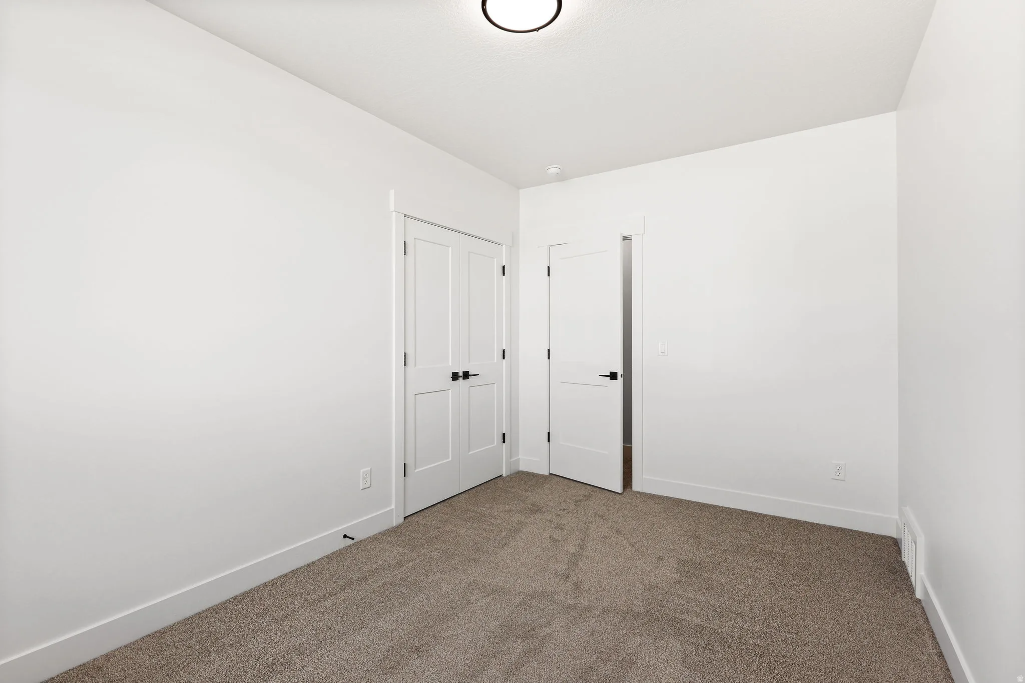 Empty room with dark carpet and baseboards