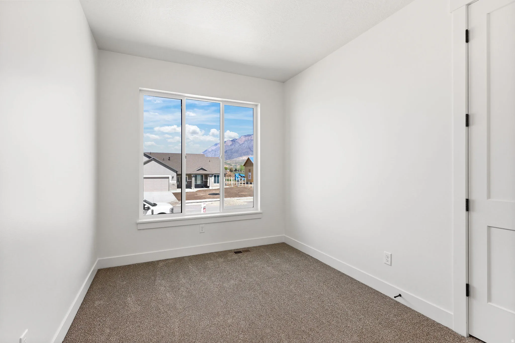 Unfurnished room featuring dark carpet and a mountain view