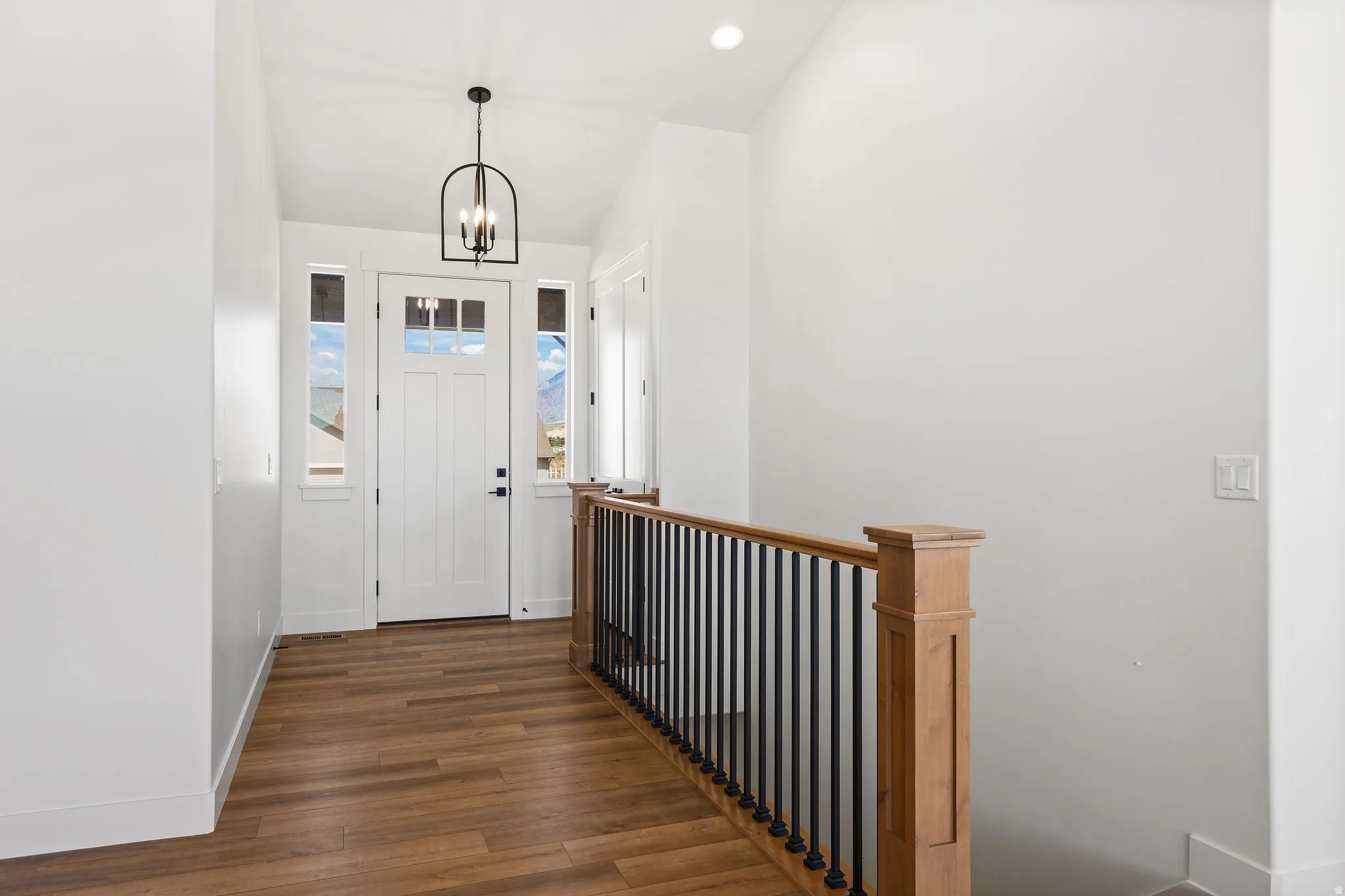 Entrance foyer featuring dark wood-type flooring and a chandelier
