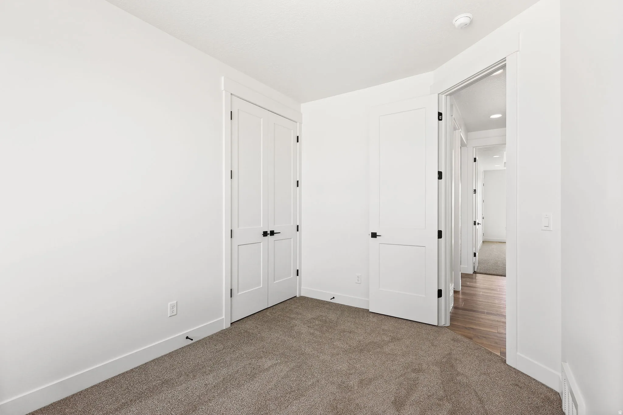 Unfurnished bedroom featuring dark carpet and a closet