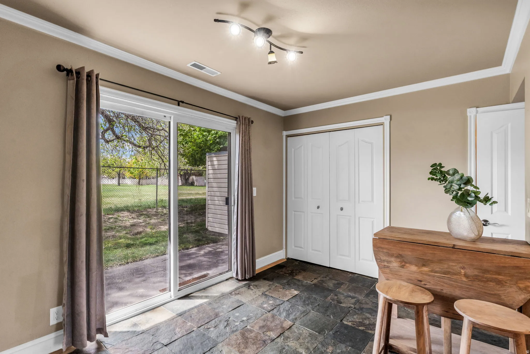 Dining room featuring stone tile floors and ornamental molding