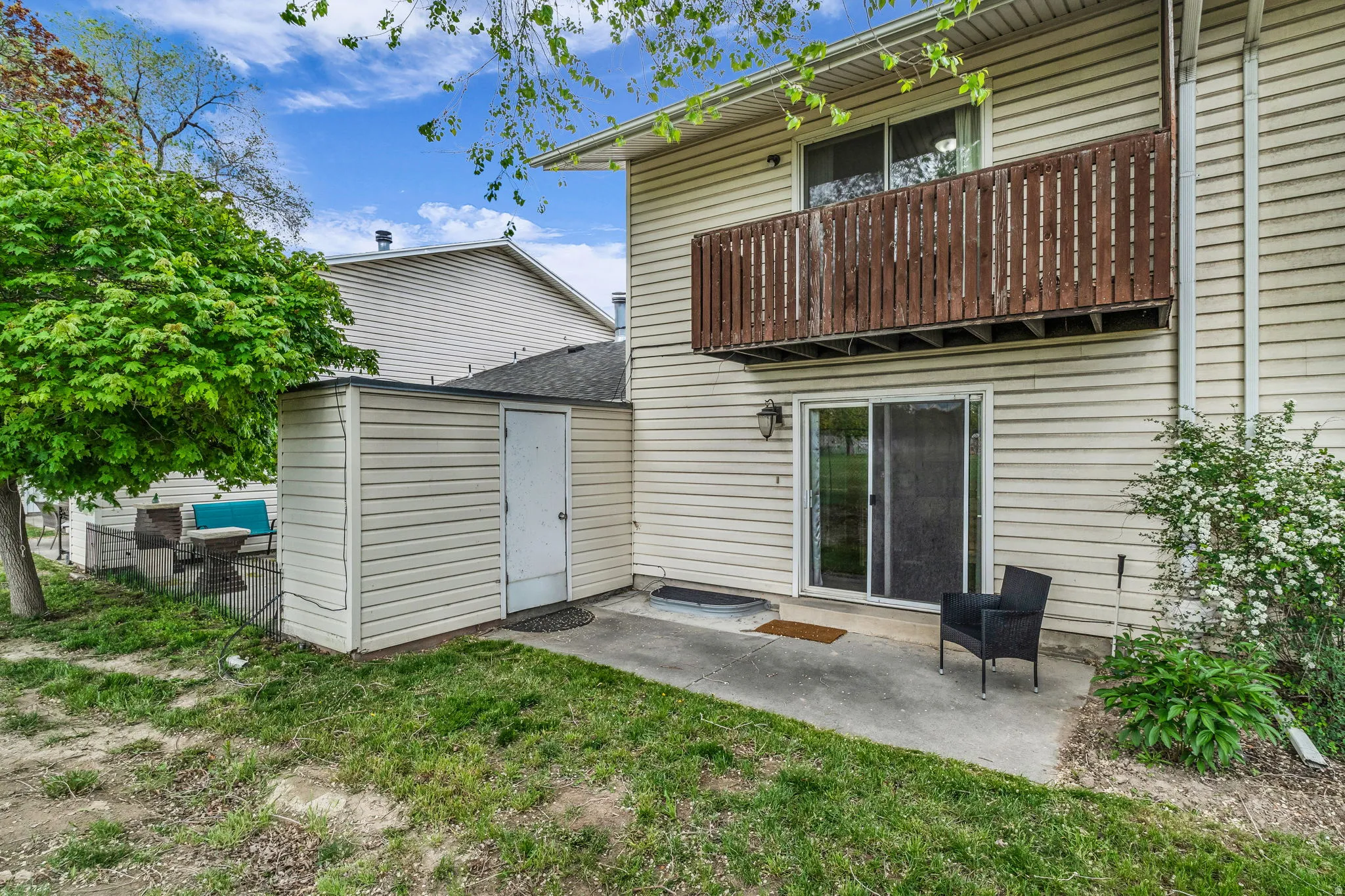 Back of property featuring a patio area, a balcony, and a lawn