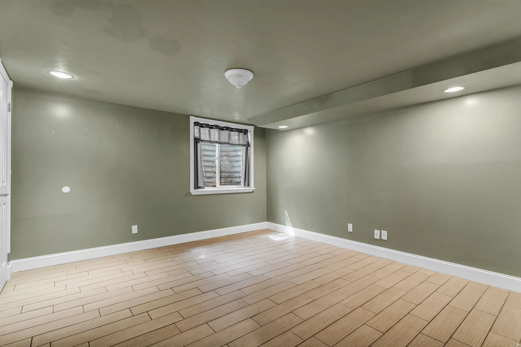 Empty room with wood finish floors and recessed lighting