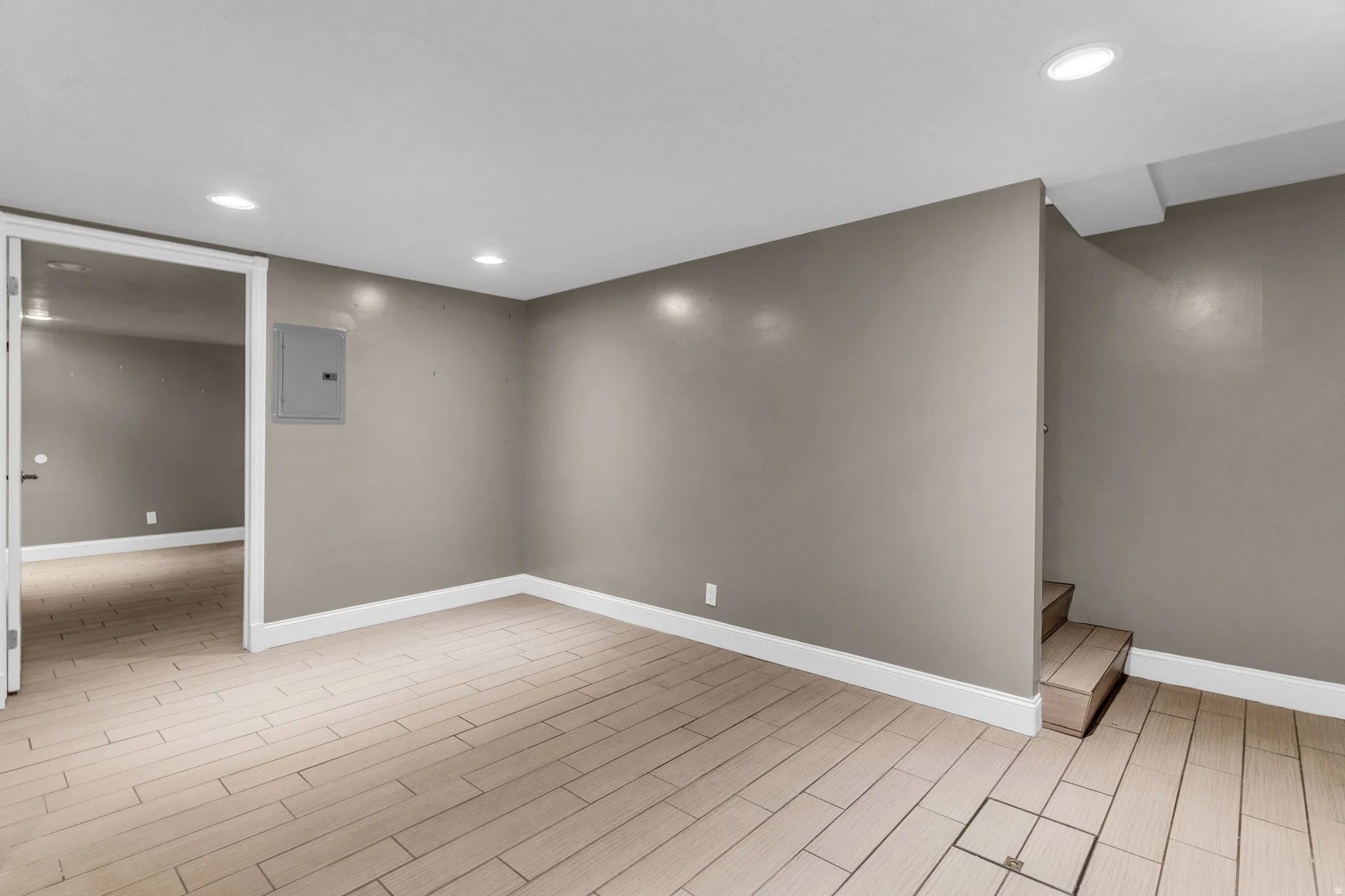 Finished basement featuring recessed lighting, wood tiled floors, and electric panel