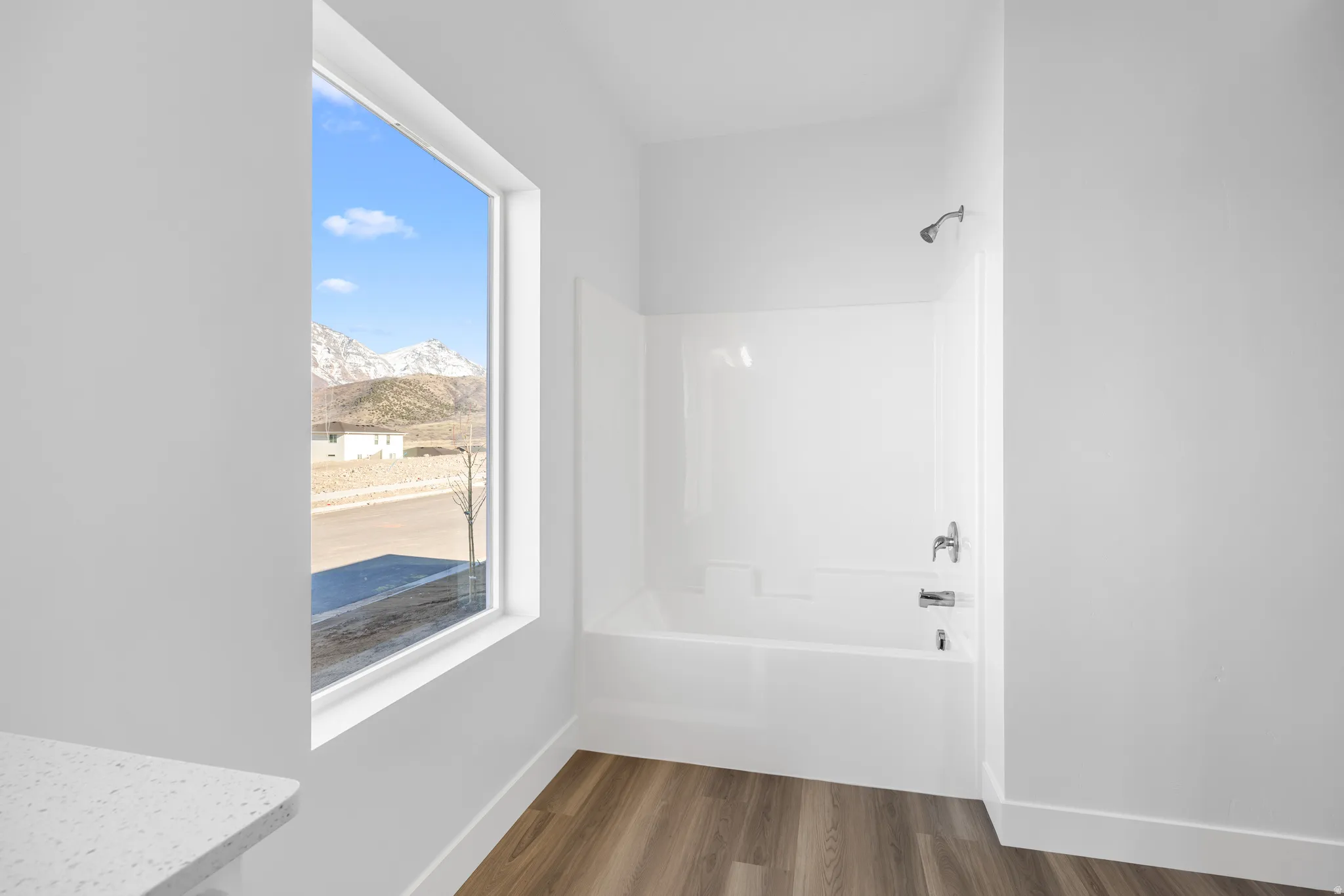 Full bath with wood finished floors, a mountain view, shower / bath combination, and vanity