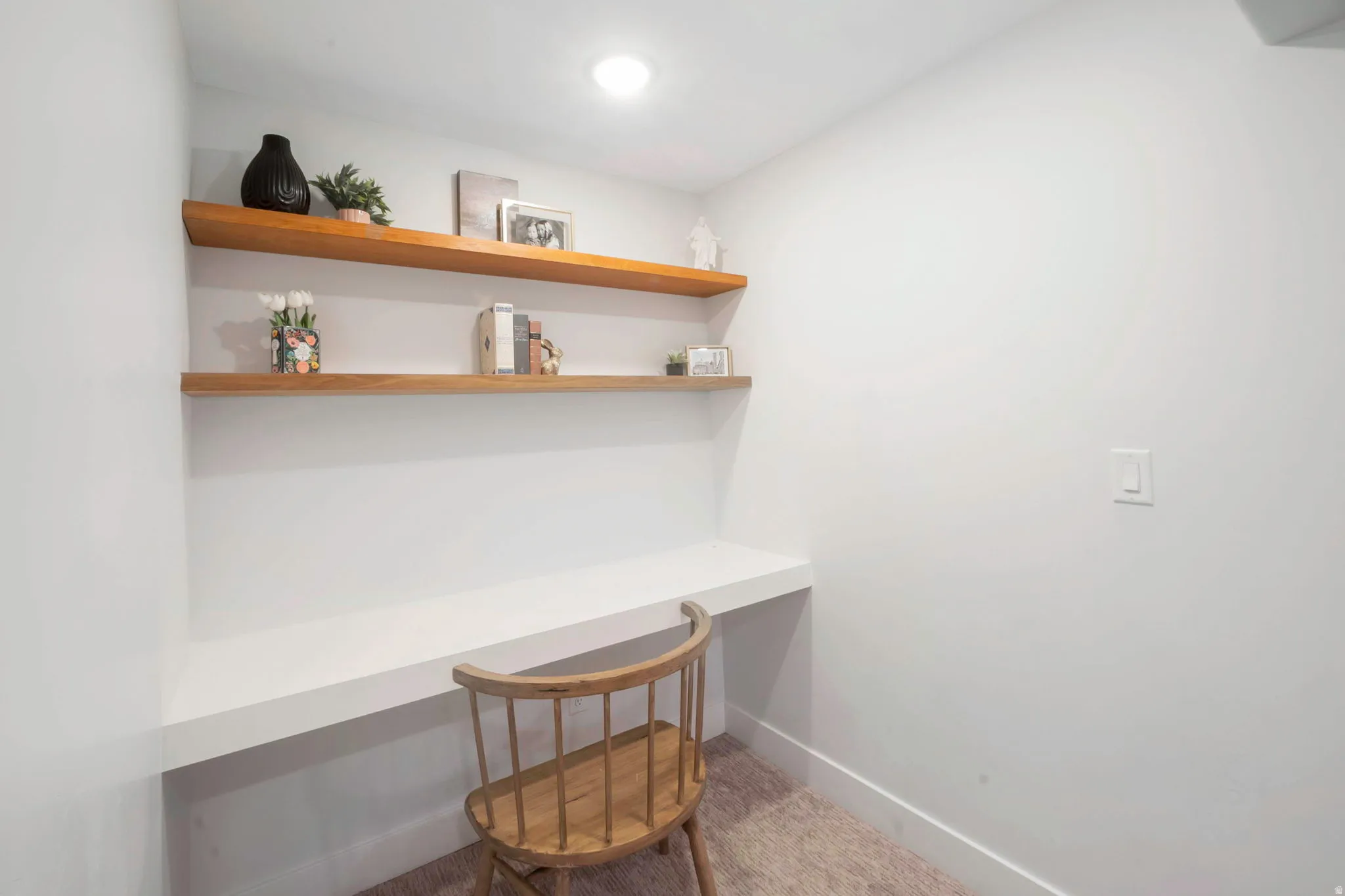 Office area featuring built in study area and light colored carpet