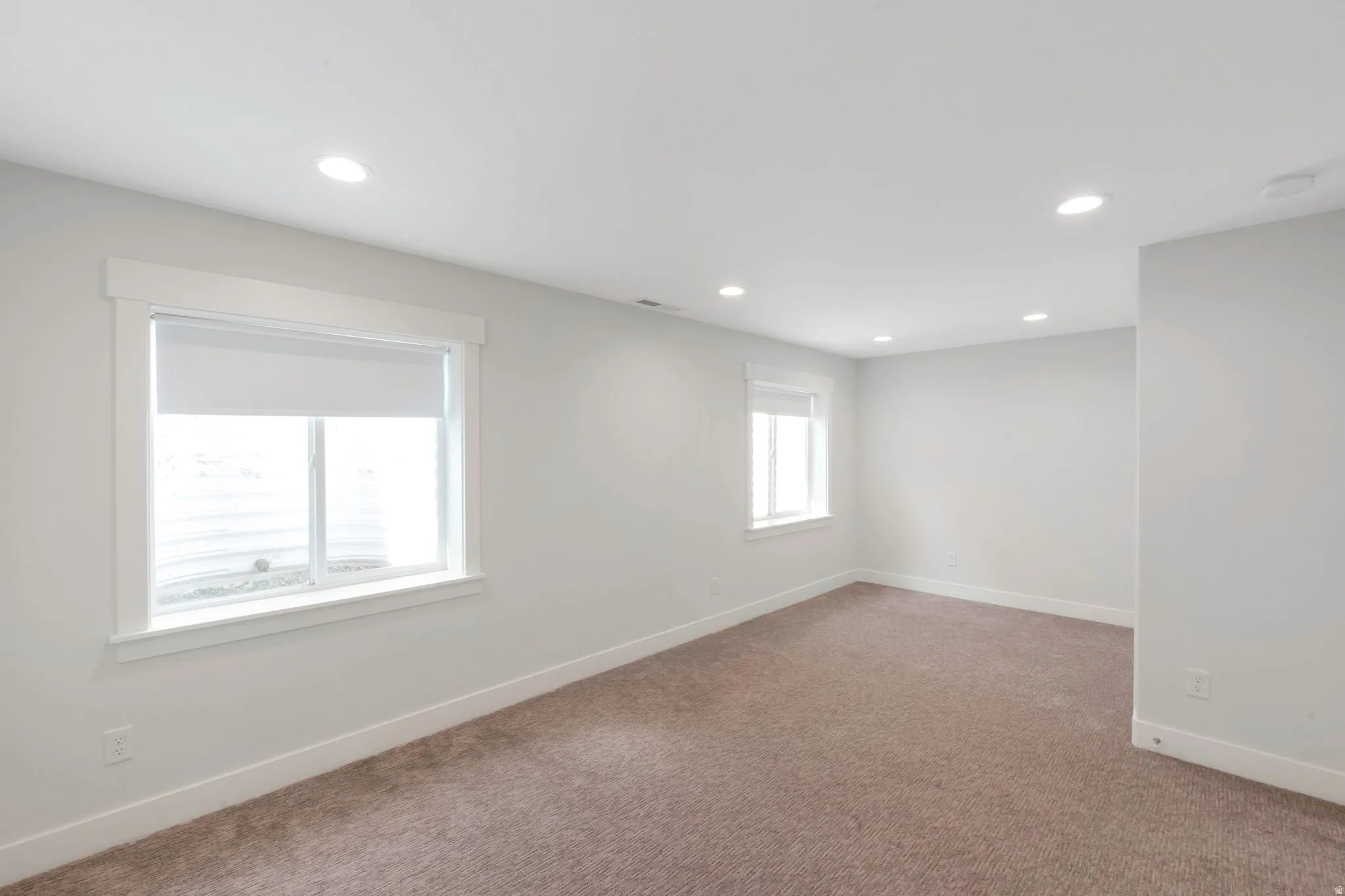Carpeted empty room with baseboards and recessed lighting