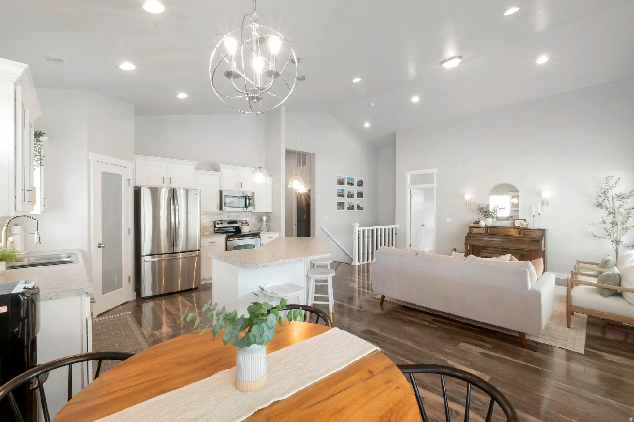 Dining space featuring lofted ceiling, dark wood-style floors, and hanging lights
