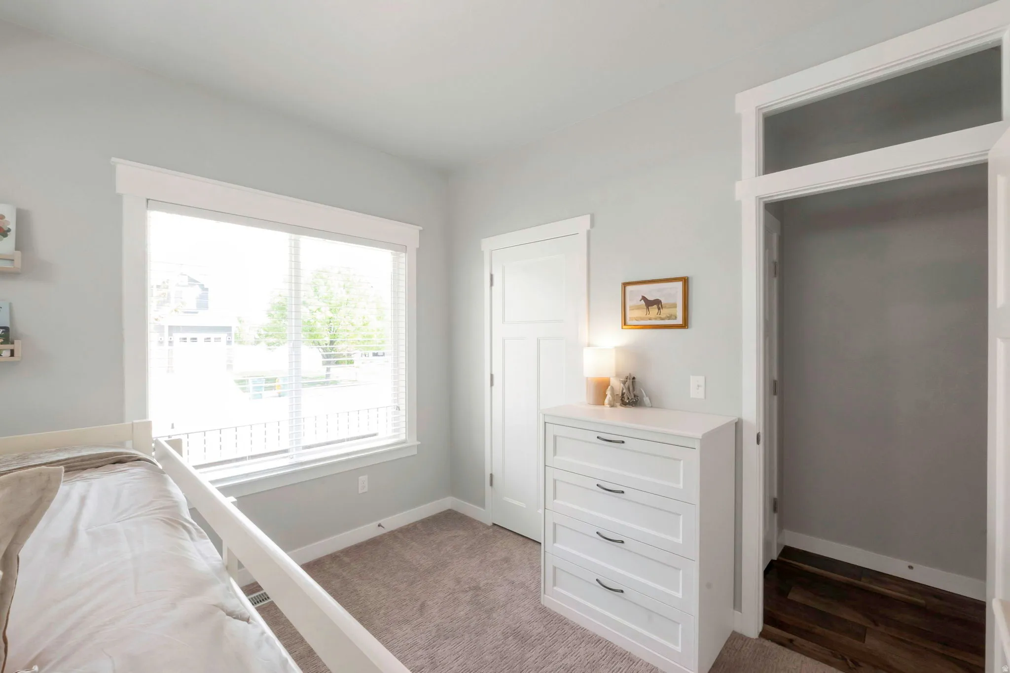Bedroom with baseboards and light carpet