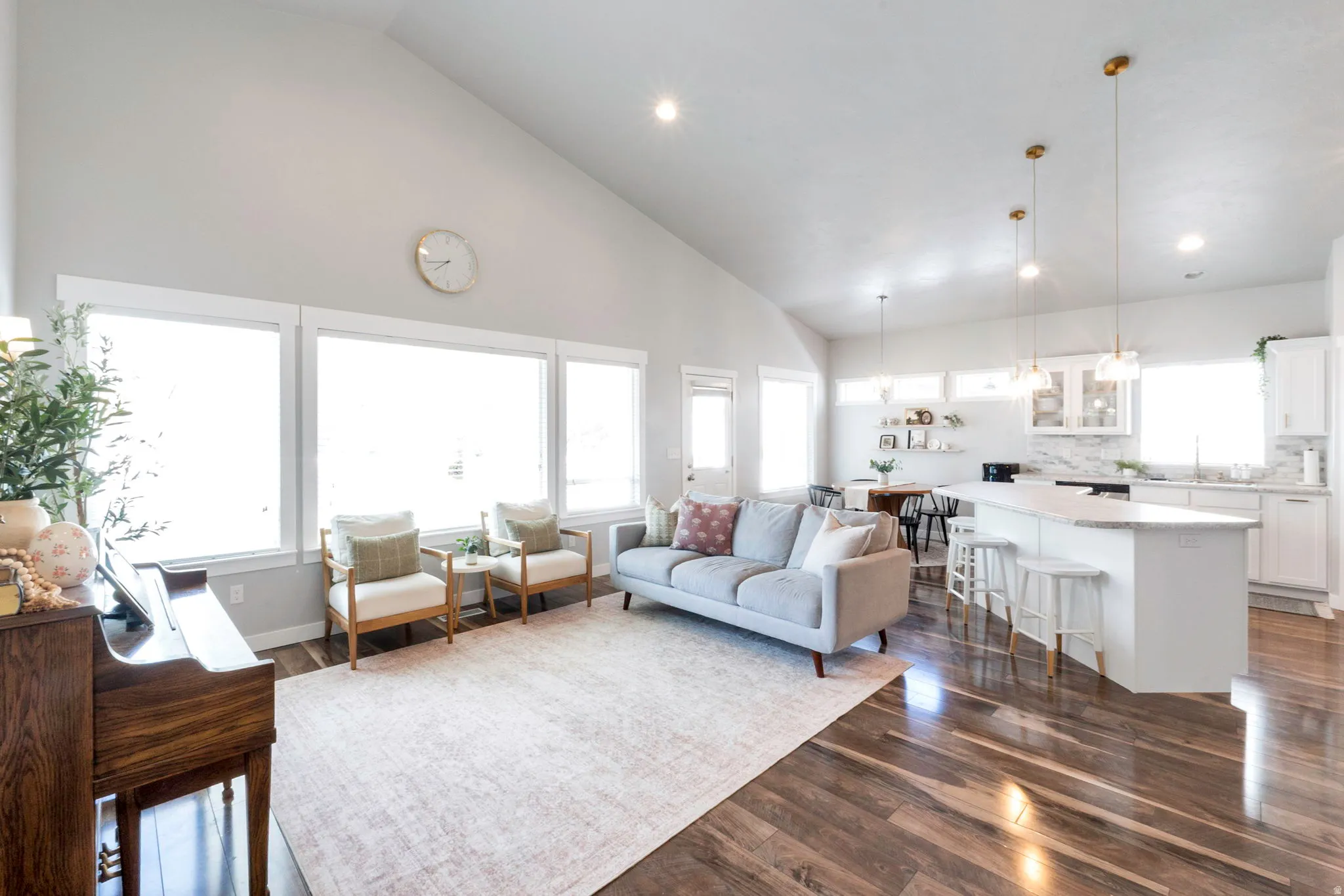 Living room with lofted ceiling, recessed lighting, and dark wood-style flooring