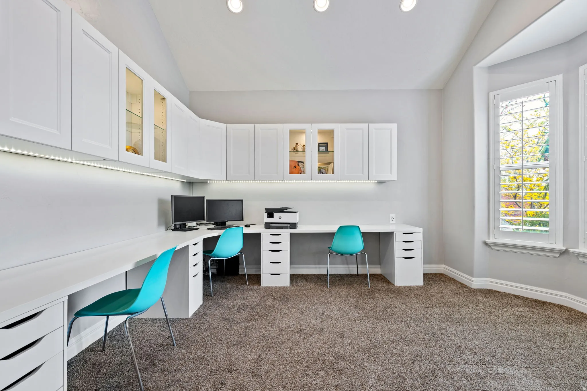 Office with vaulted ceiling, built in study area, dark carpet, and recessed lighting