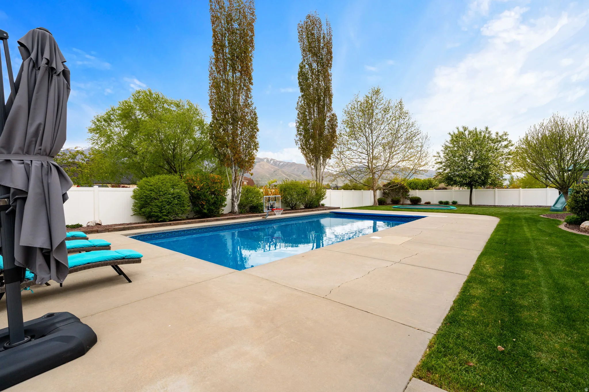 View of pool featuring a fenced backyard, patio surround, and a mountain view