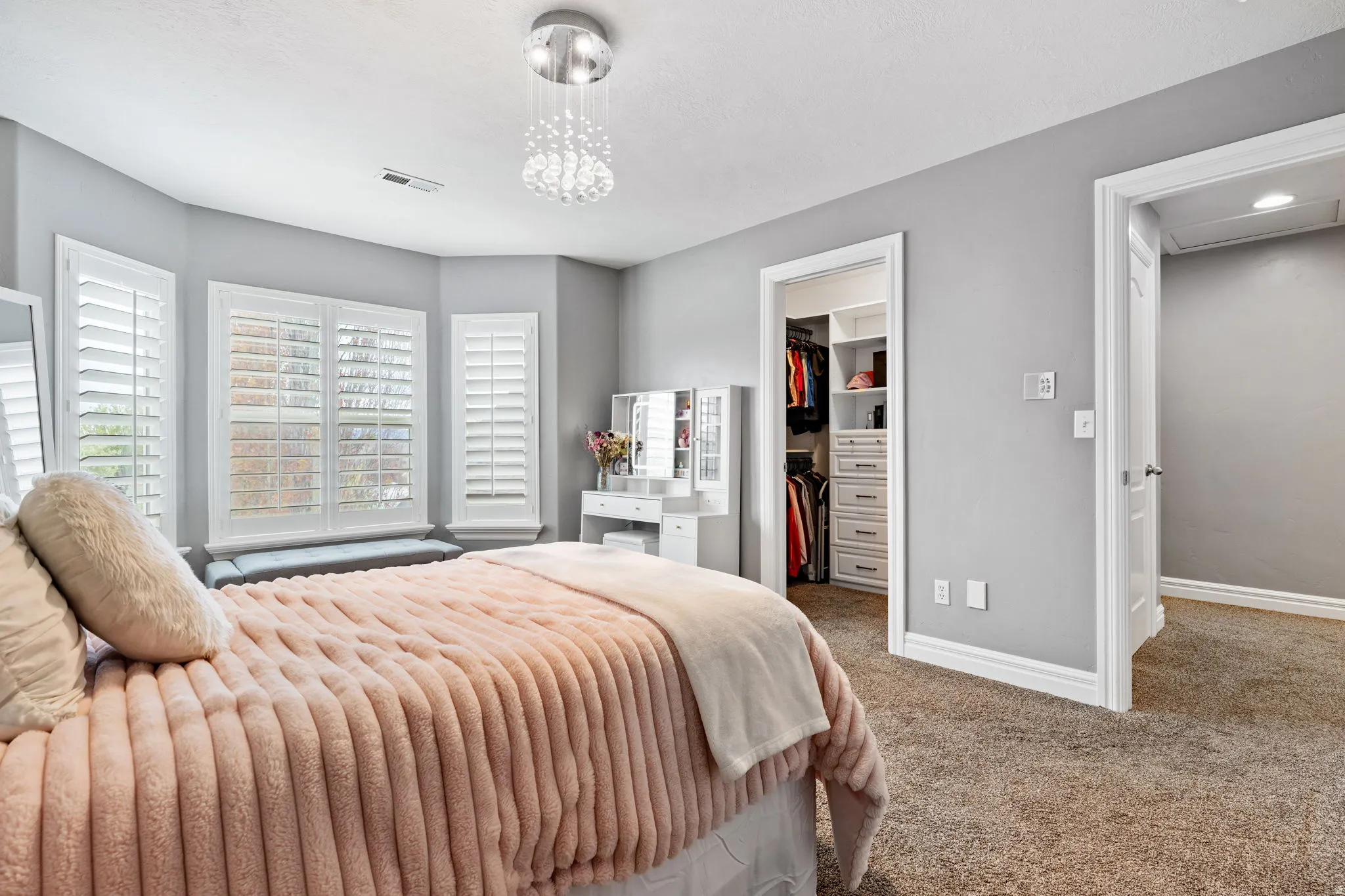 Carpeted bedroom featuring a walk in closet and baseboards