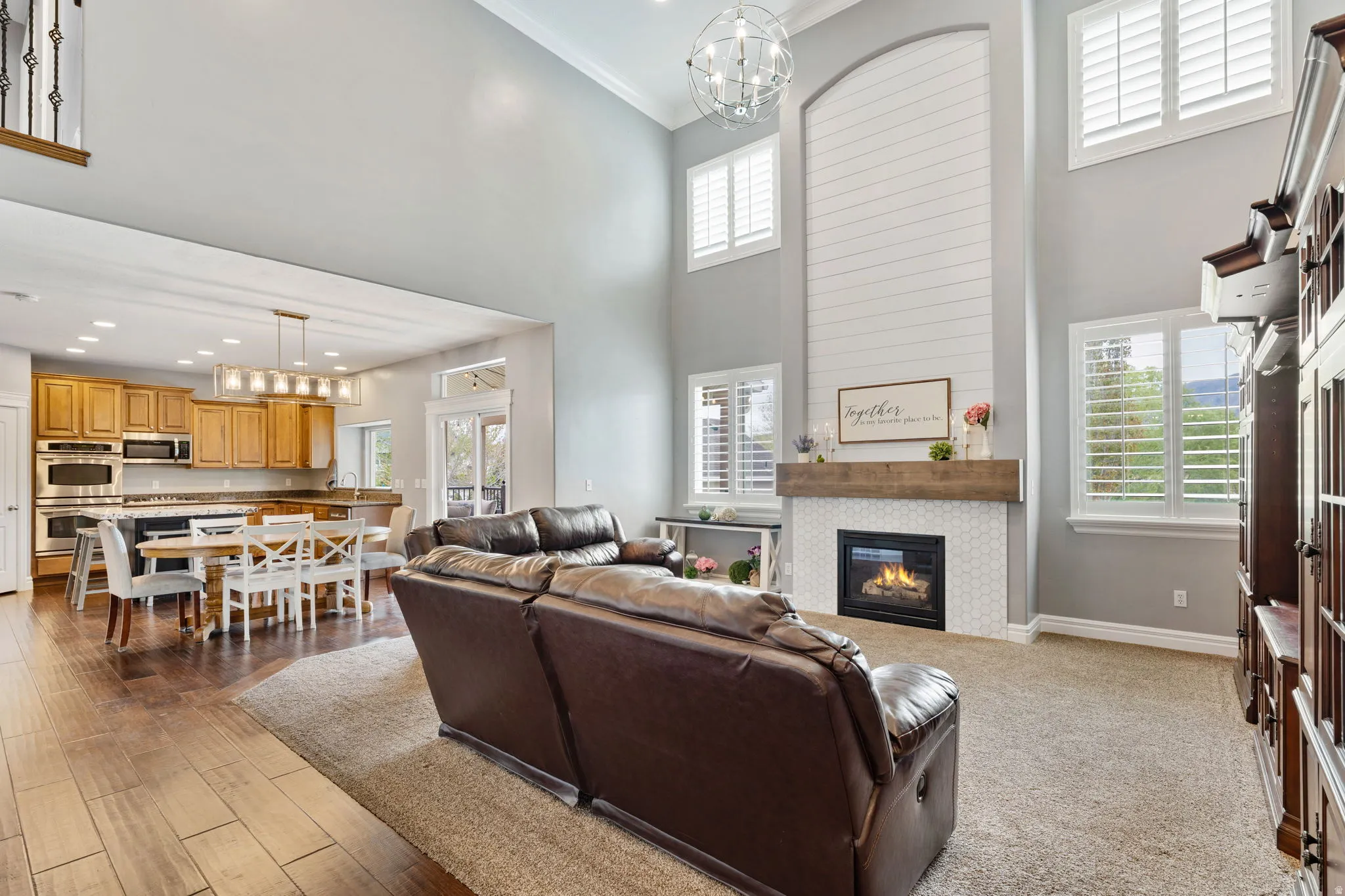 Living room with a chandelier, a fireplace, and a high ceiling