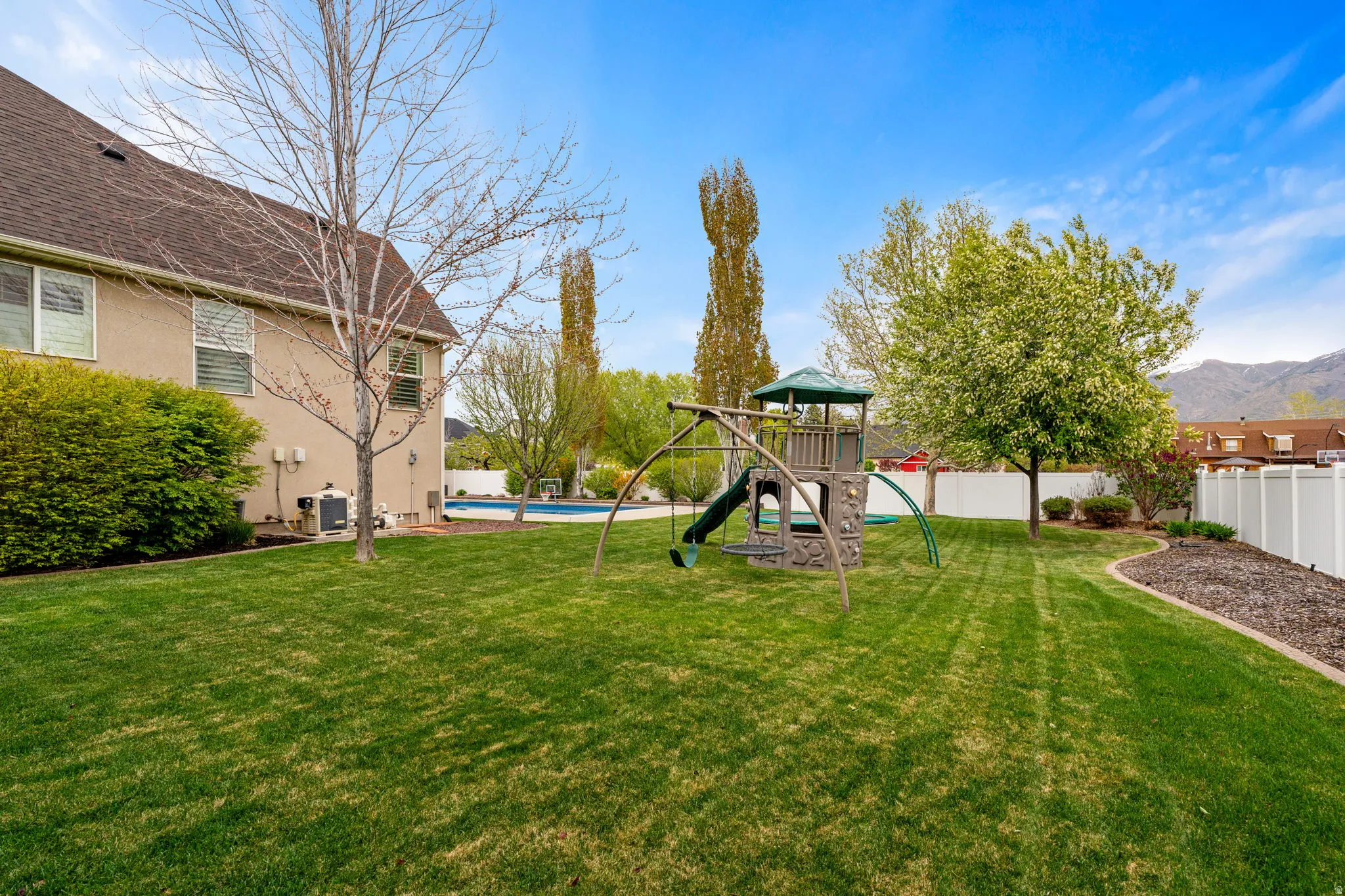 Fenced backyard featuring a mountain view and a playground