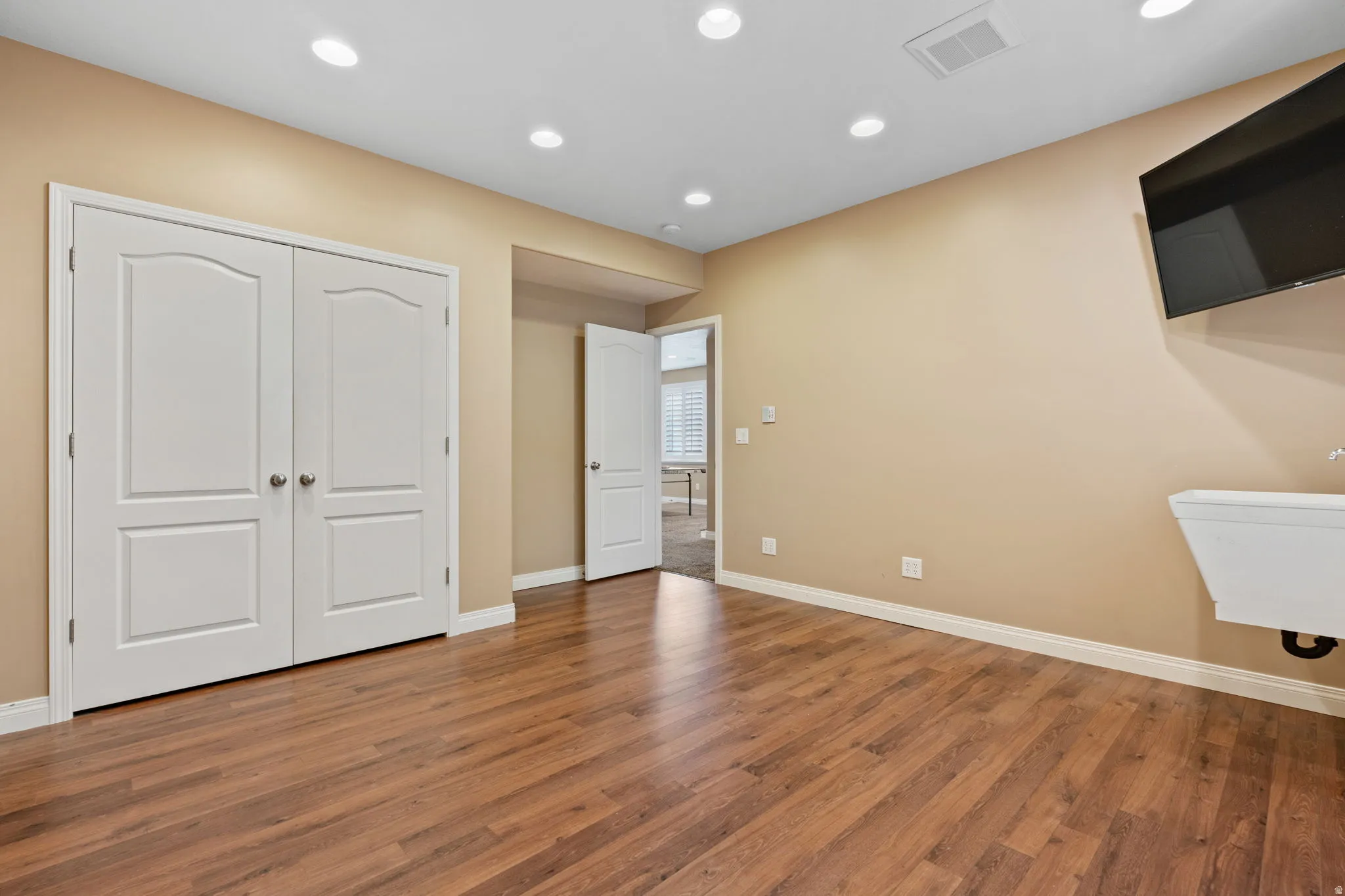 Unfurnished bedroom with dark wood-style floors, a closet, and recessed lighting