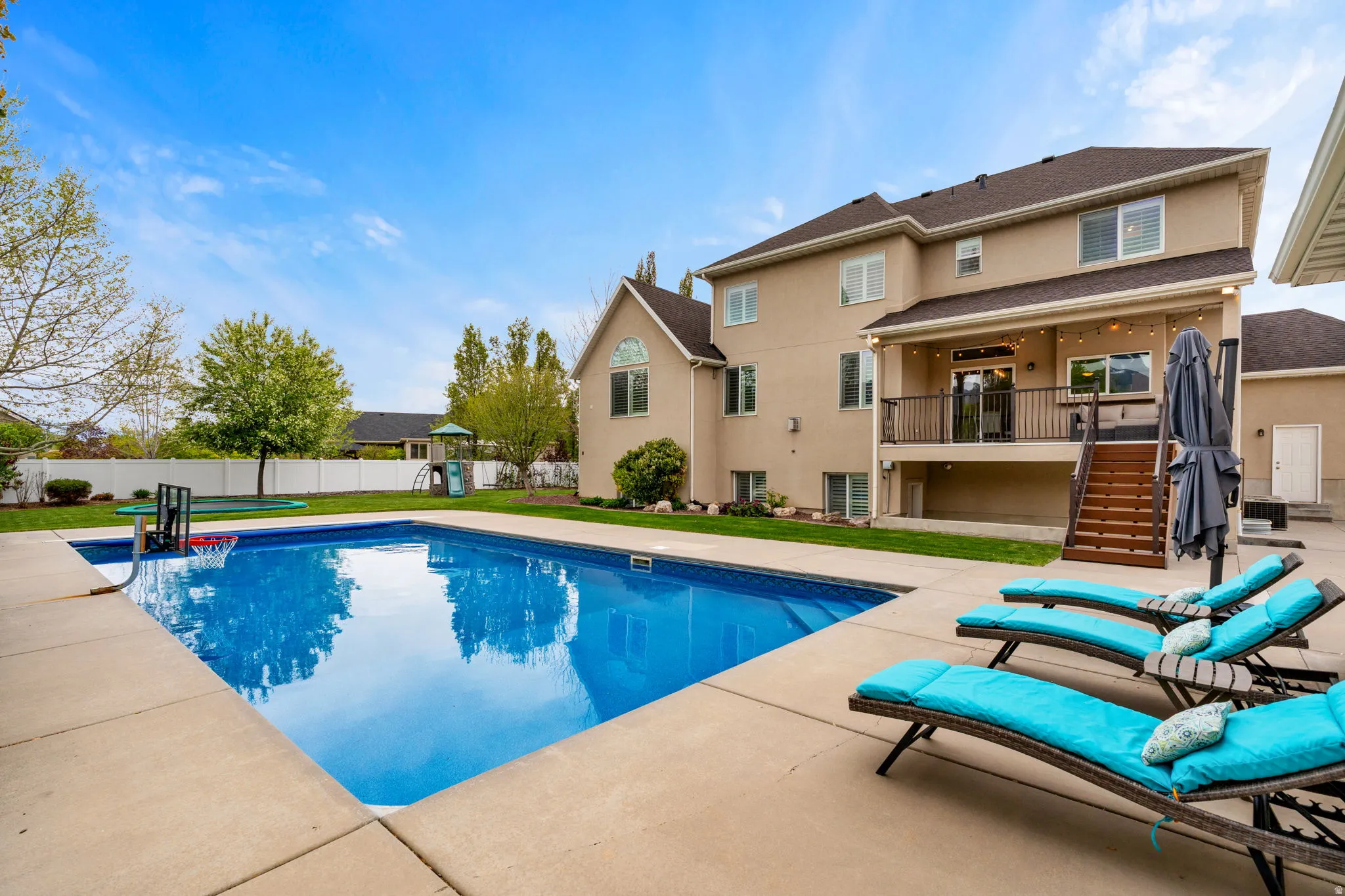 View of pool with patio surround, a balcony, and a fenced backyard