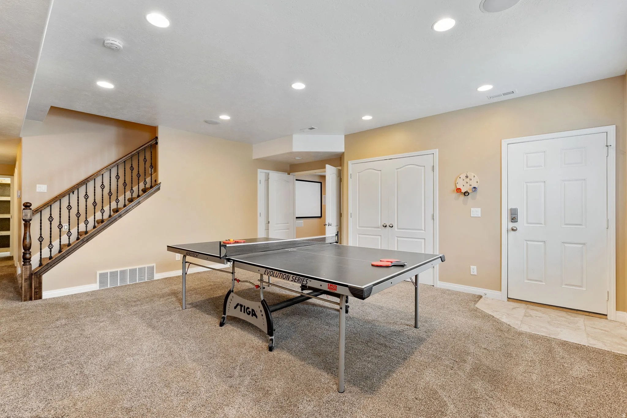 Recreation room featuring light colored carpet and recessed lighting