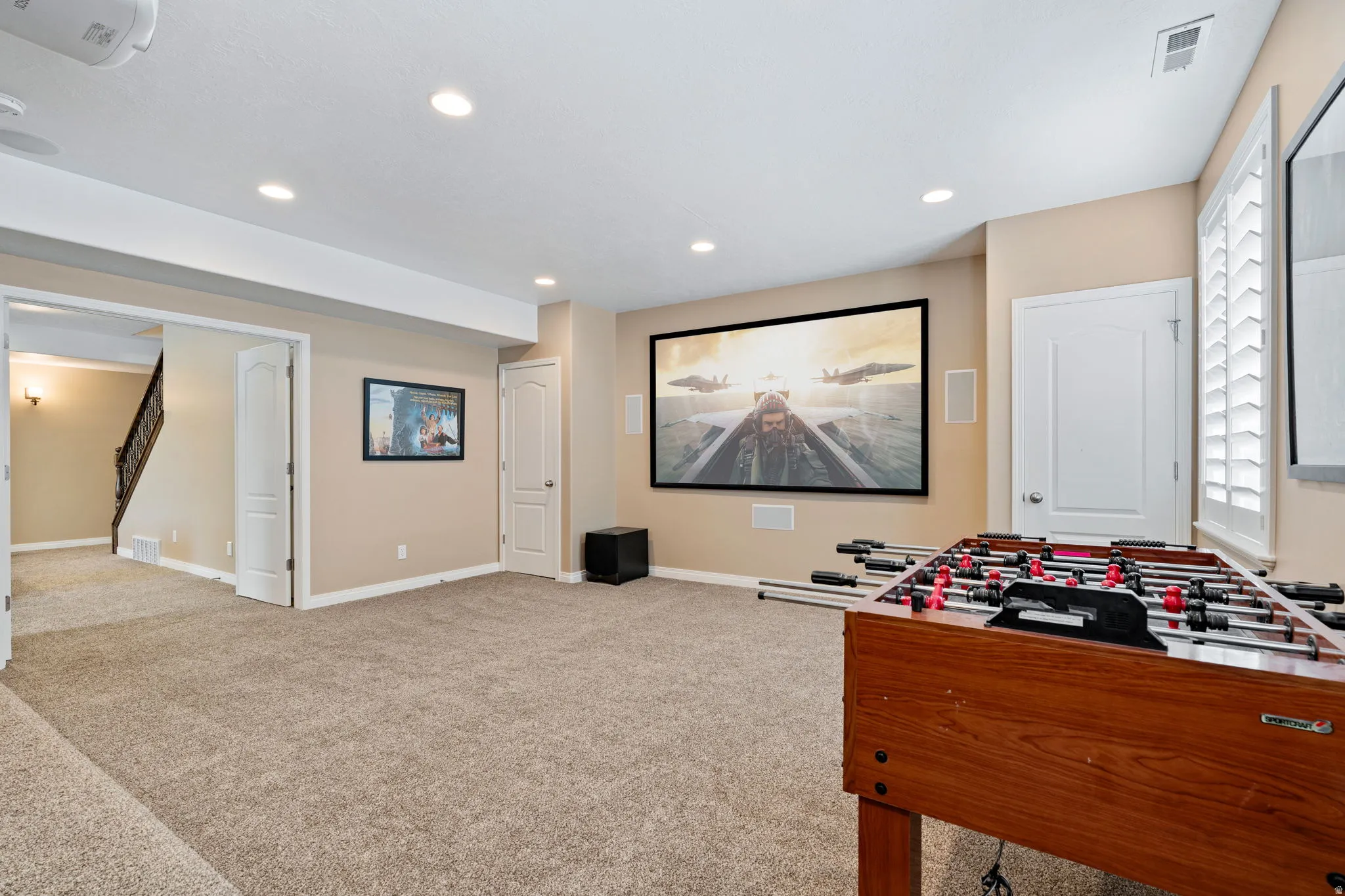 Game room with light colored carpet and recessed lighting