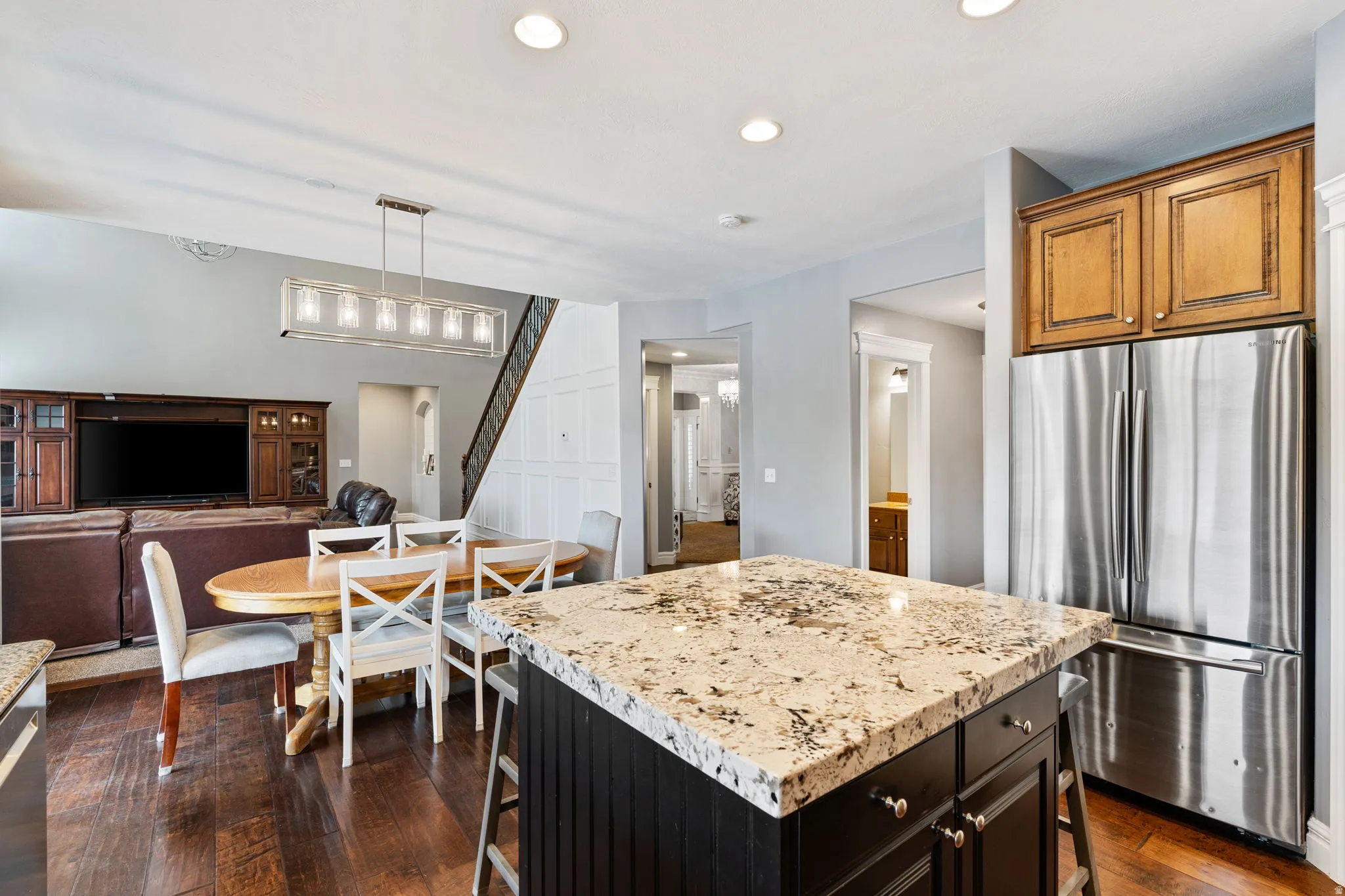 Kitchen featuring a breakfast bar, freestanding refrigerator, a center island, light stone countertops, and open floor plan