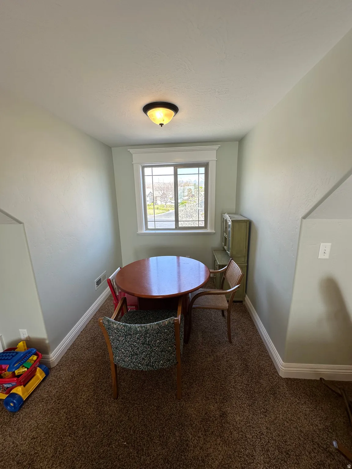 Dining area with baseboards and dark colored carpet