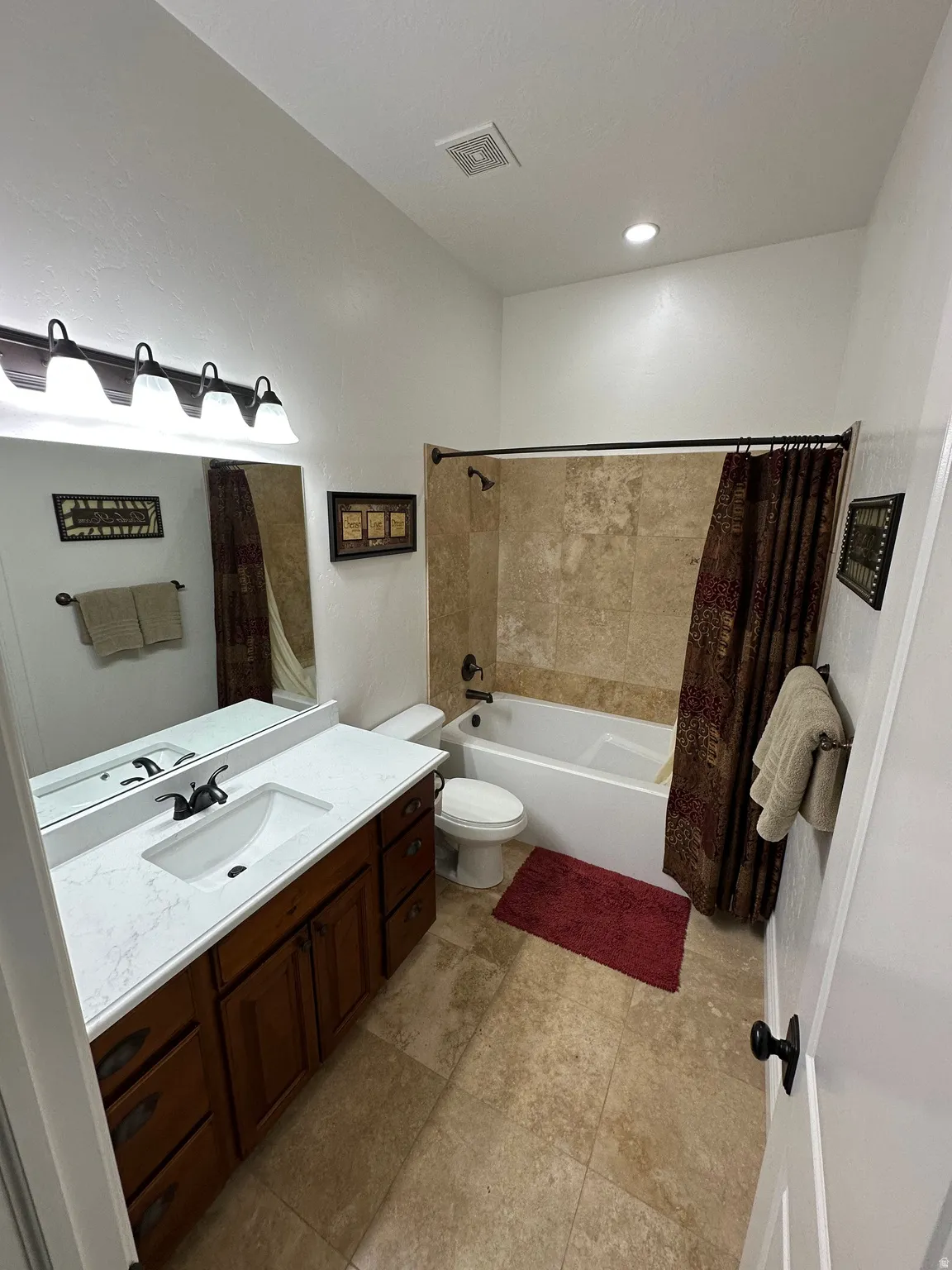 Bathroom featuring vanity and shower / bath combination with curtain