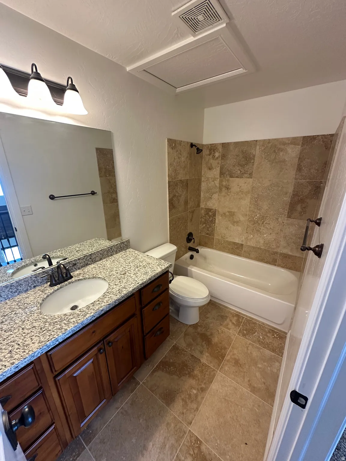 Bathroom featuring vanity,  shower combination, a textured wall, and a textured ceiling