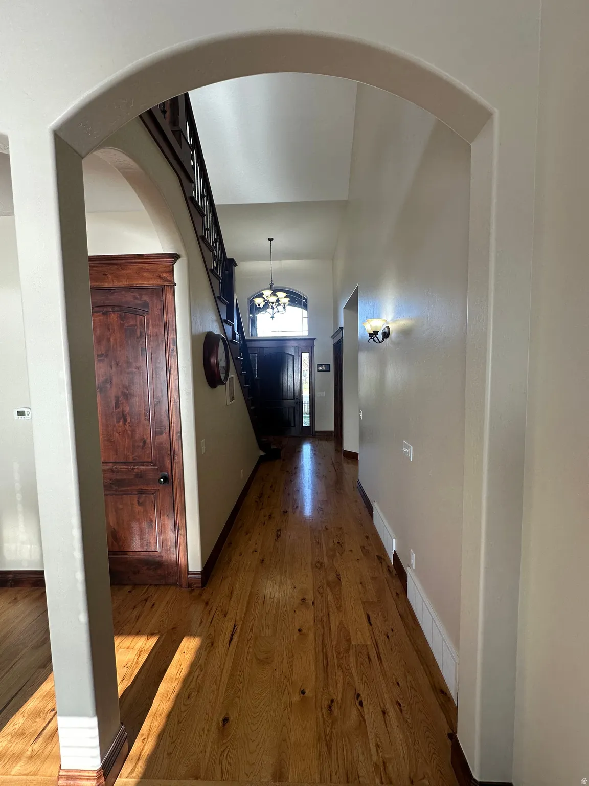 Hall with dark wood-type flooring and arched walkways