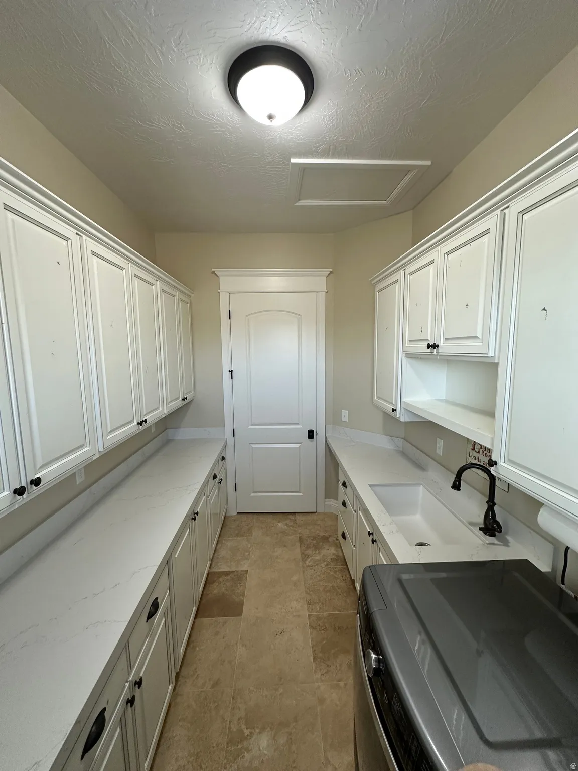Laundry area featuring washer / clothes dryer and a textured ceiling