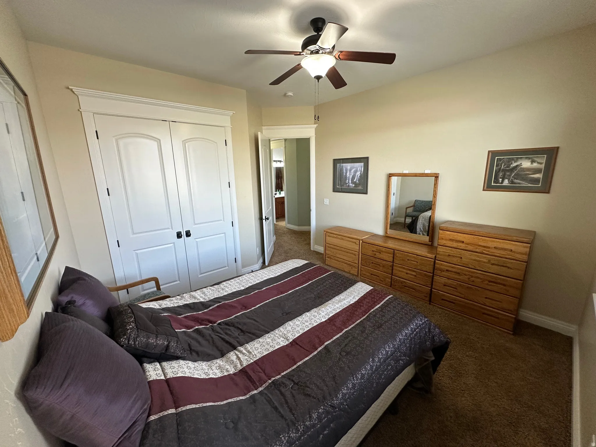 Bedroom with dark colored carpet, a closet, and a ceiling fan