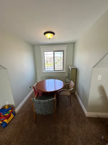 Dining area with baseboards and dark colored carpet