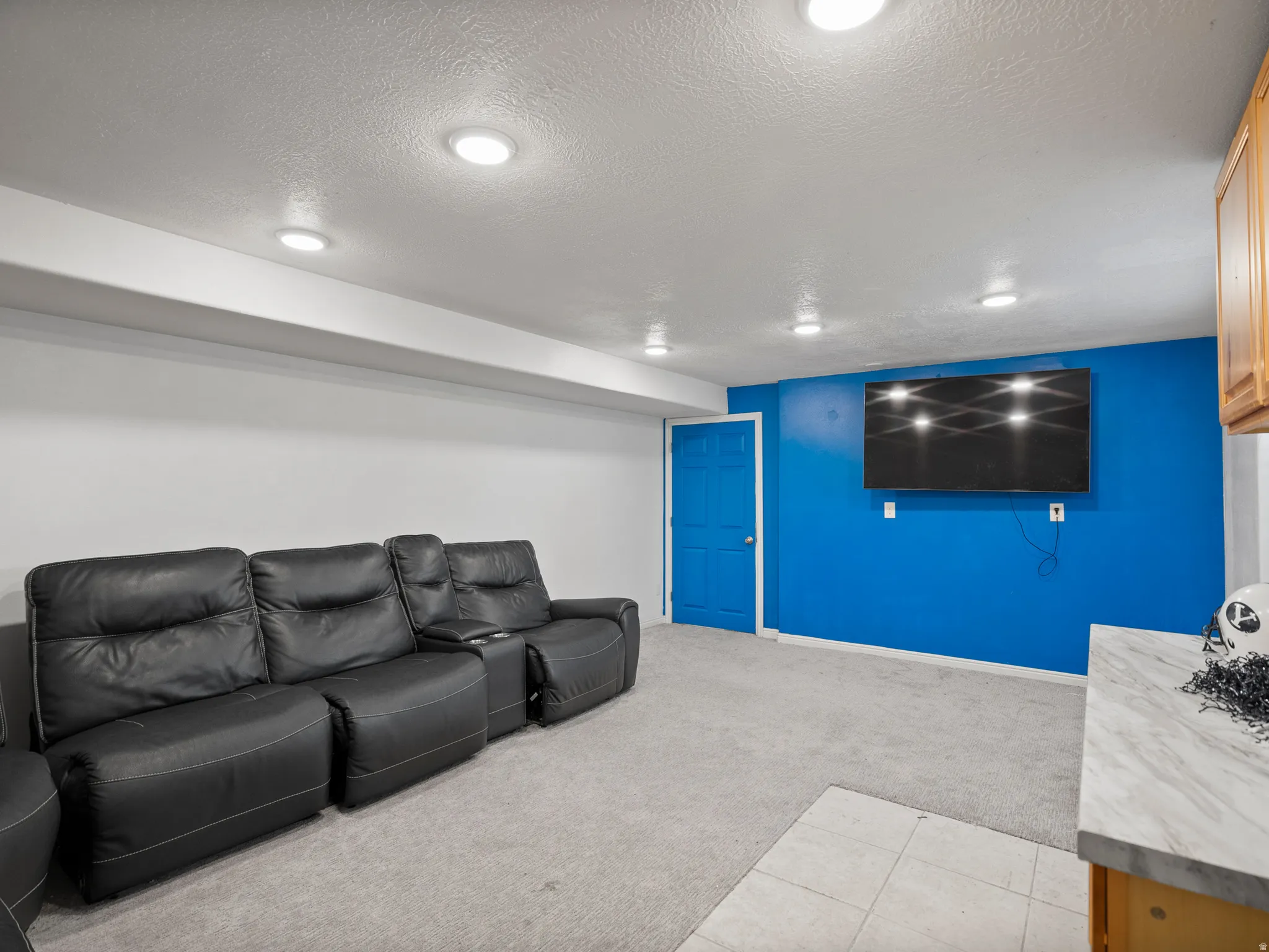 Living room featuring light carpet, a textured ceiling, and recessed lighting