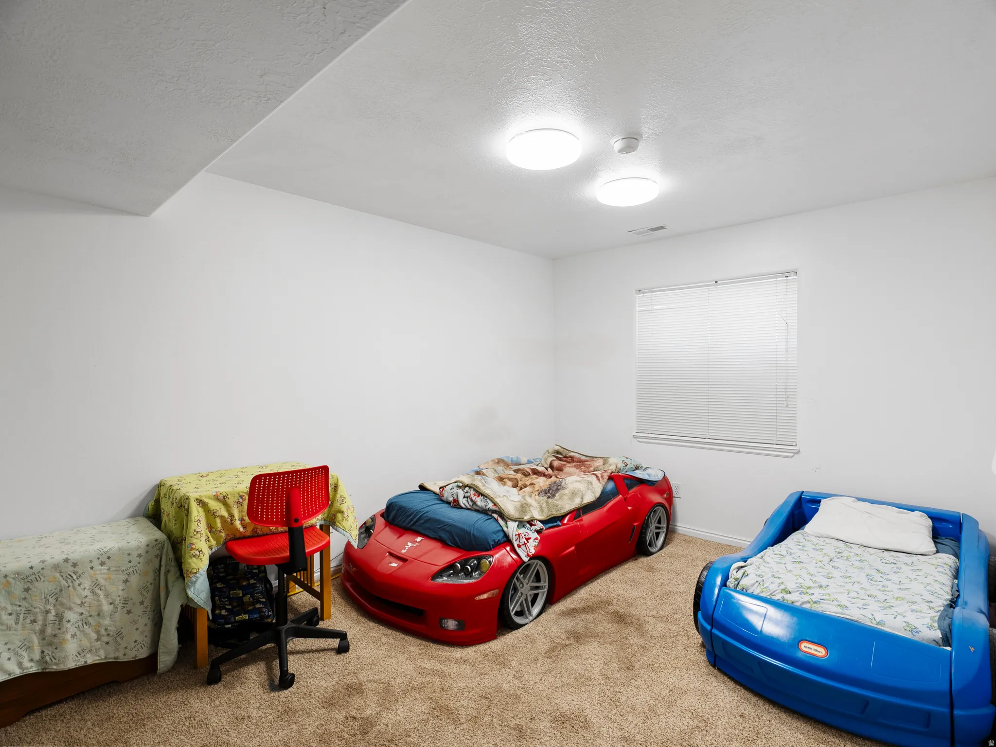 Carpeted bedroom with a textured ceiling and baseboards
