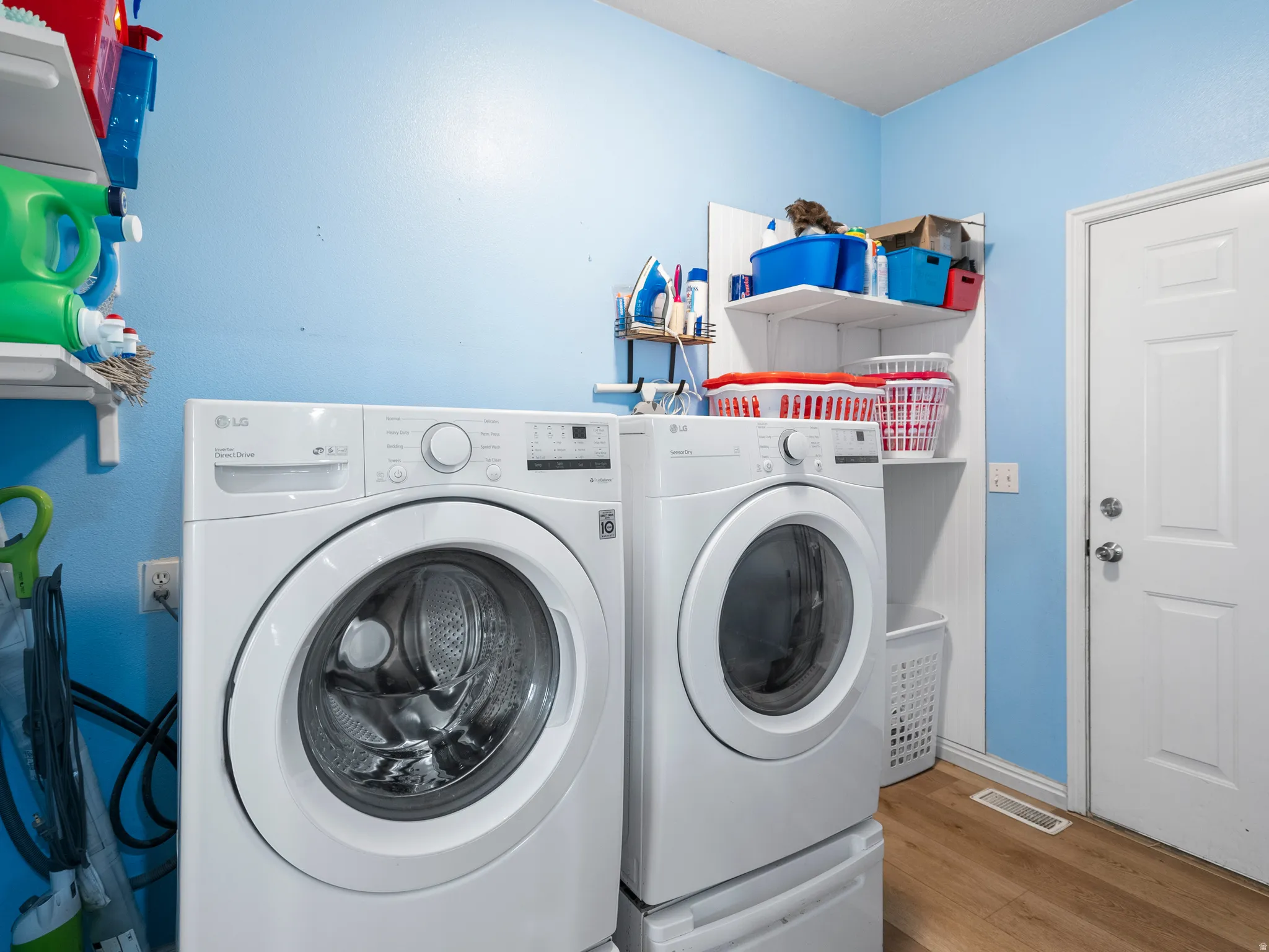 Laundry room featuring light wood-type flooring and separate washer and dryer