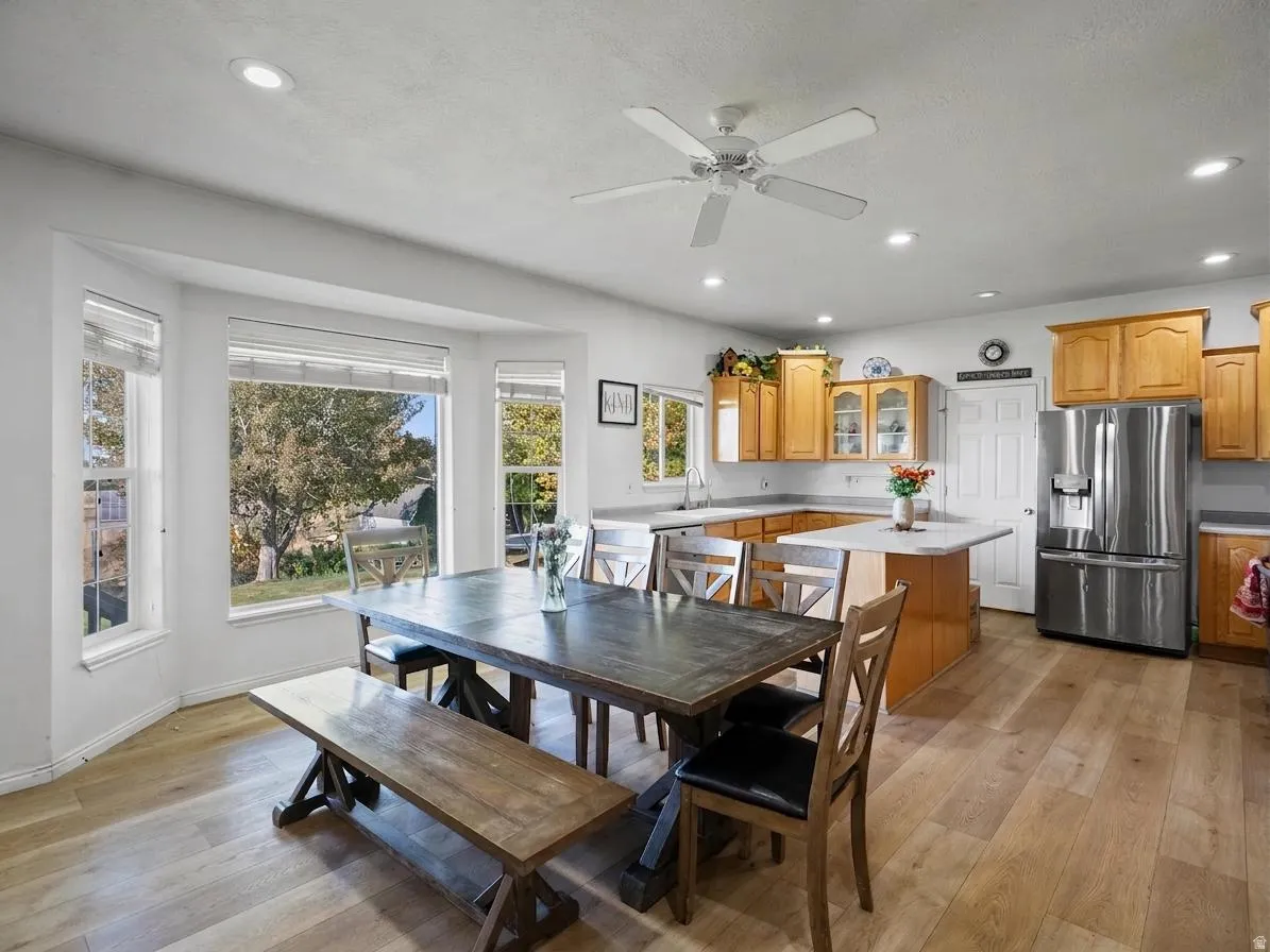 Dining space featuring light wood-style floors, ceiling fan, and recessed lighting