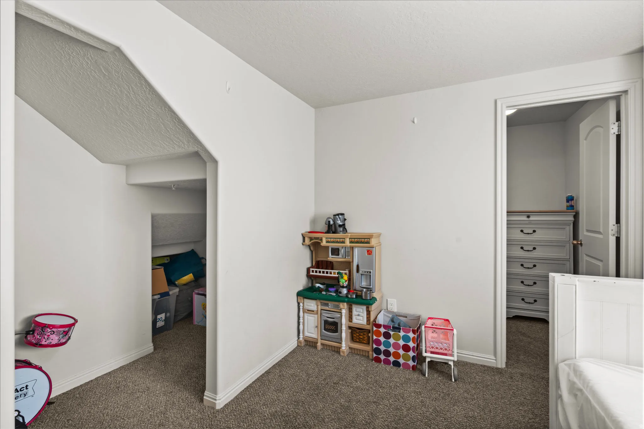 Playroom featuring a textured ceiling and dark carpet