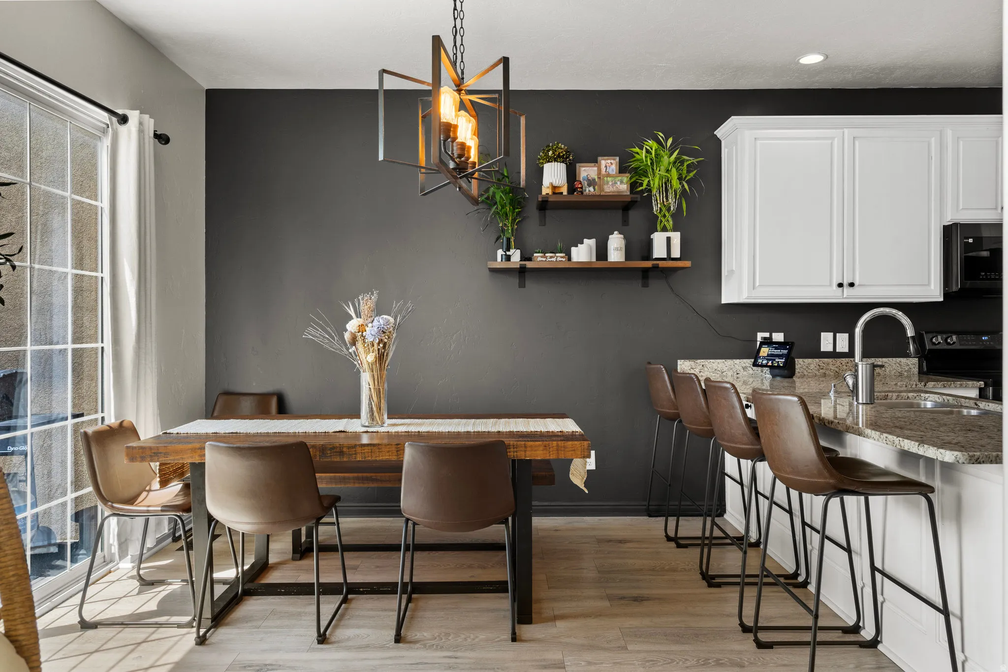 Dining room with light wood-style floors and suspended lighting