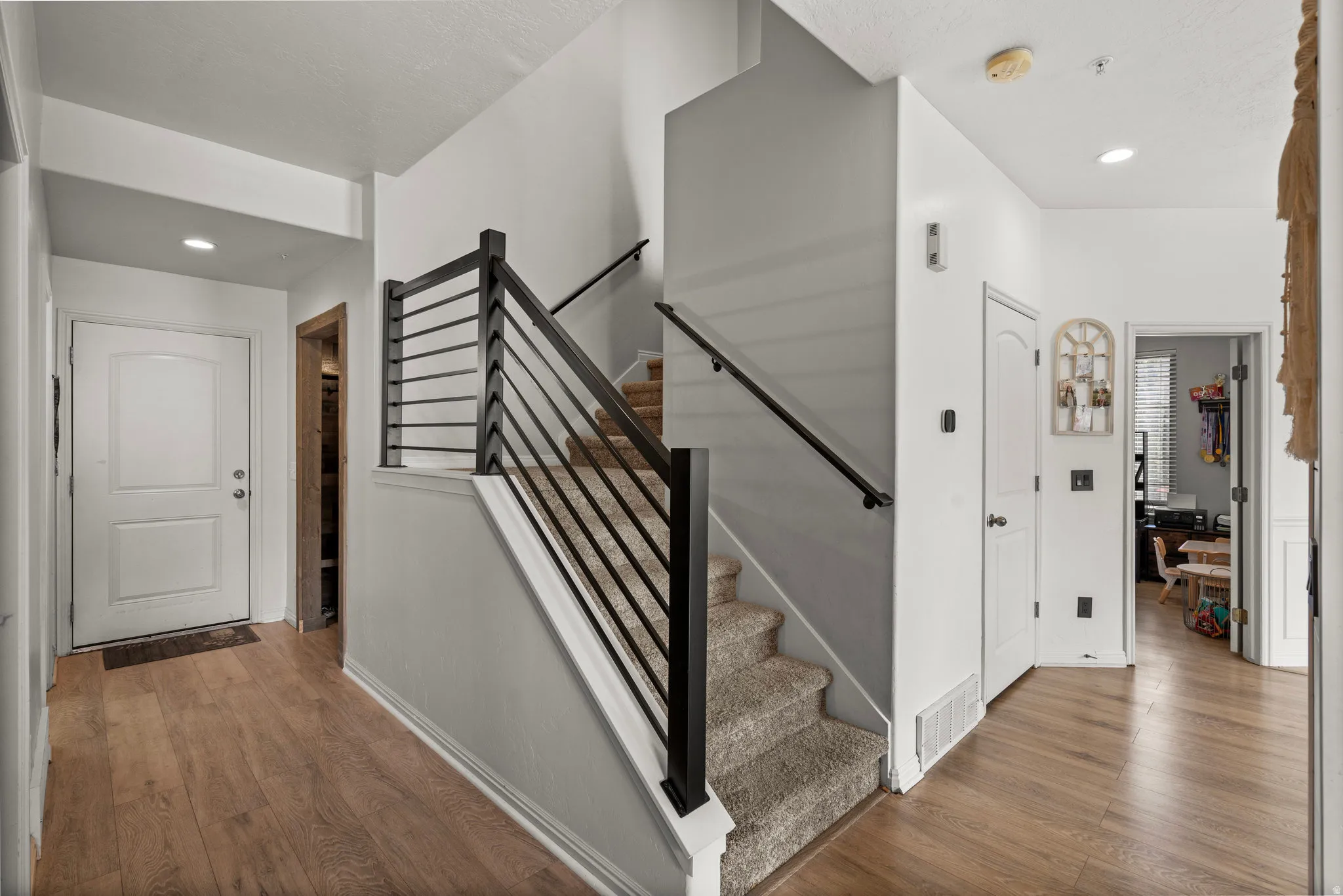 Staircase featuring wood finished floors and recessed lighting