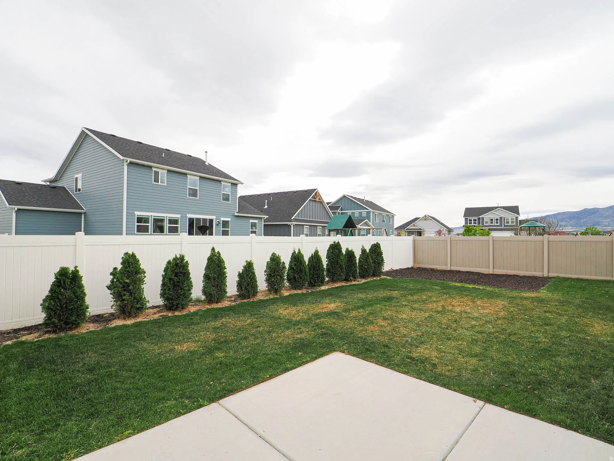 Fenced backyard with a residential view and a patio area