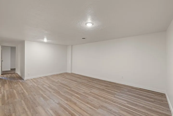 Empty room featuring a textured ceiling and light wood-type flooring