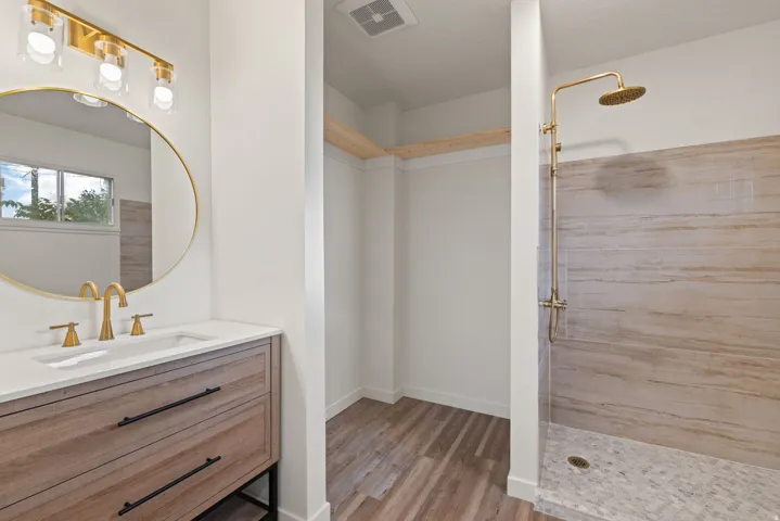 Bathroom with vanity, a shower stall, and light wood-style floors