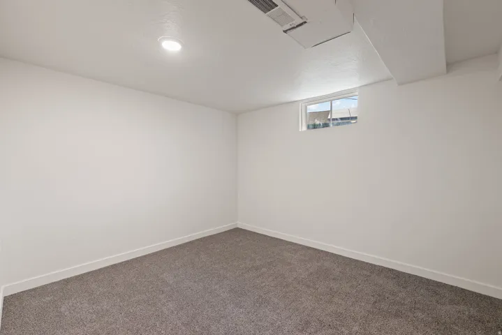 Basement featuring dark carpet and a textured ceiling