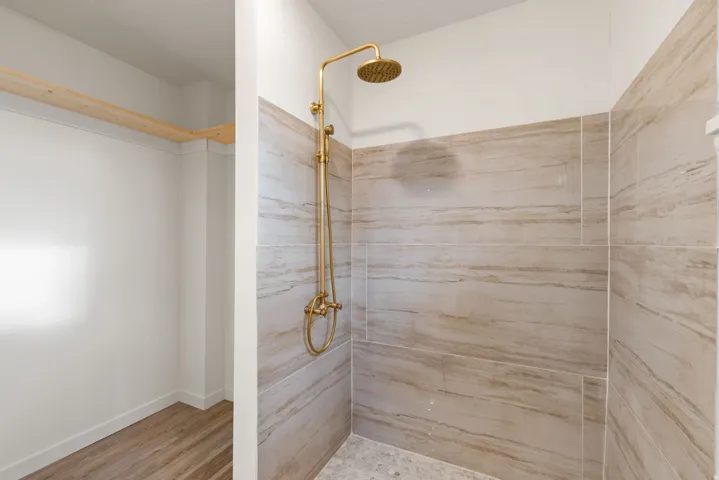 Bathroom with a tile shower and light wood-type flooring