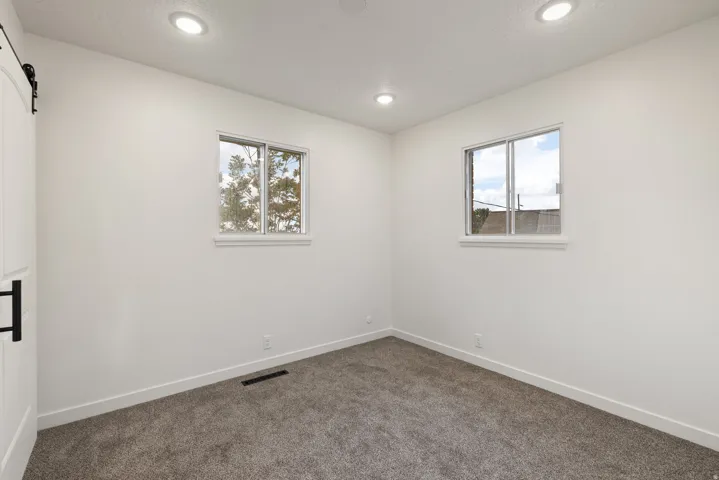 Unfurnished room with dark carpet and recessed lighting