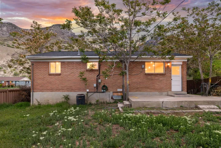 Back of property at dusk featuring brick siding