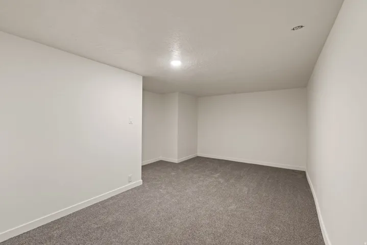 Empty room with carpet flooring and a textured ceiling